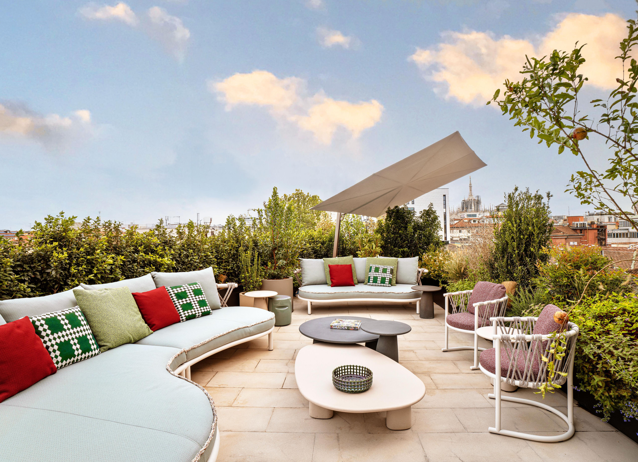 Rooftop terrace with curved outdoor sofas looking over the rooftops of Milan