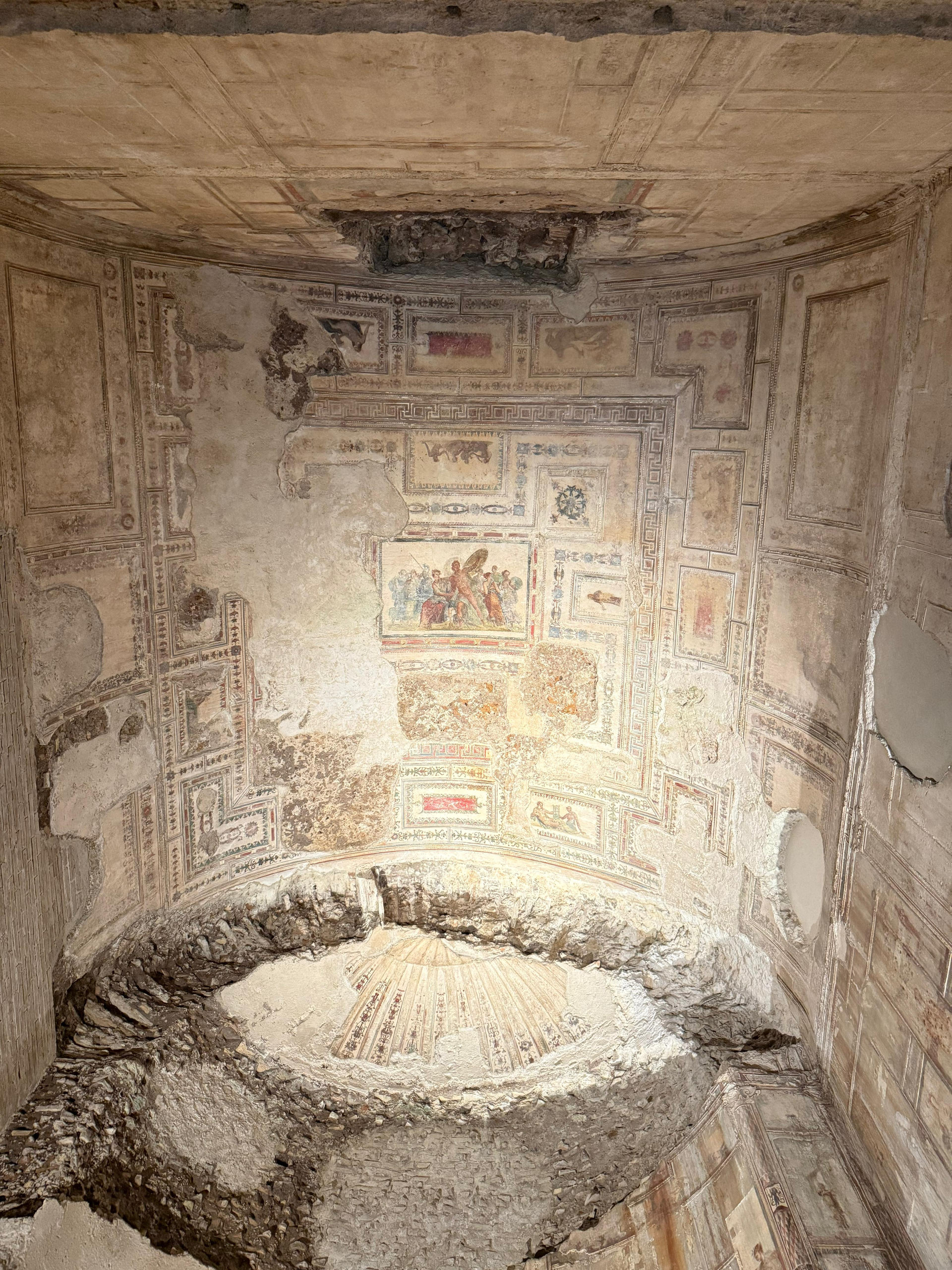 A frescoed and stuccoed vault above a circular stone basin in the Domus Aurea