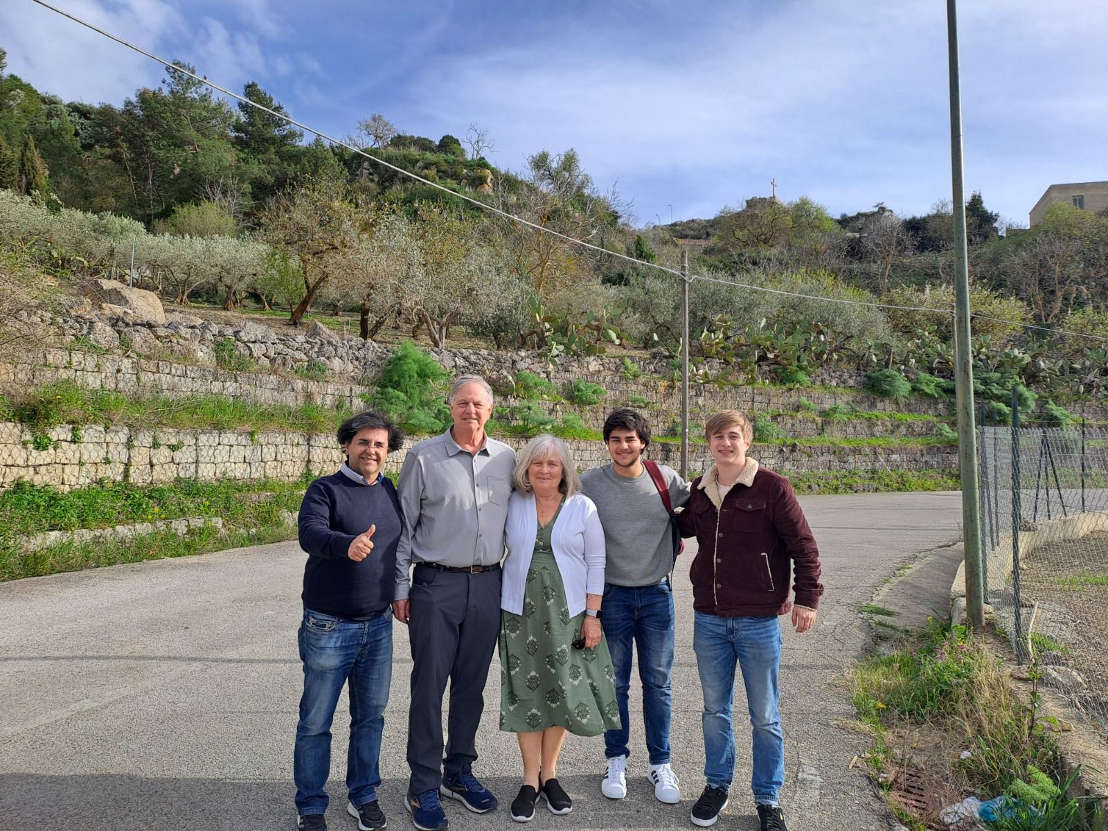 A family posing on a village road during a roots journey in Italy
