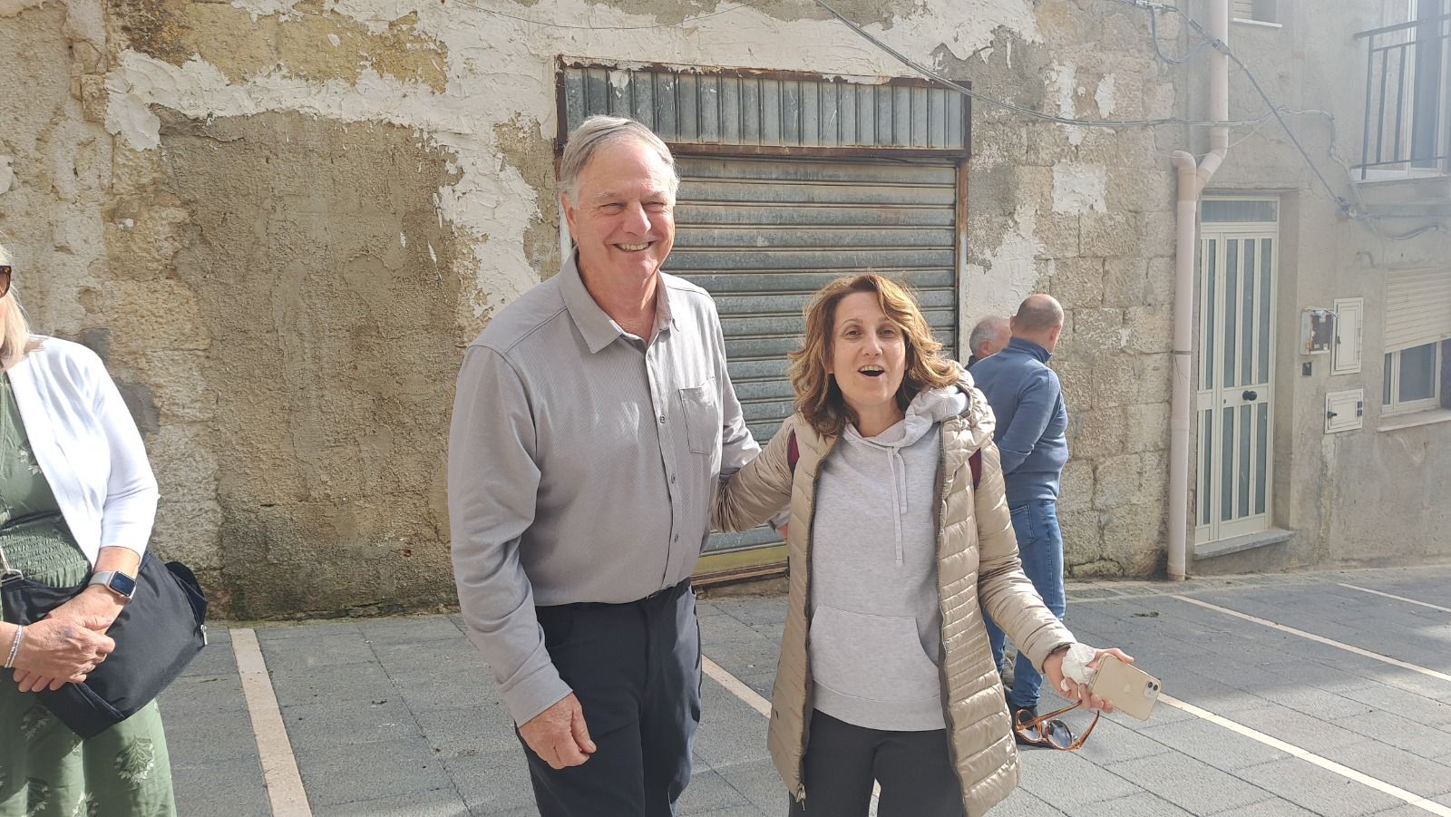 Travellers smiling in a village street during a family roots trip