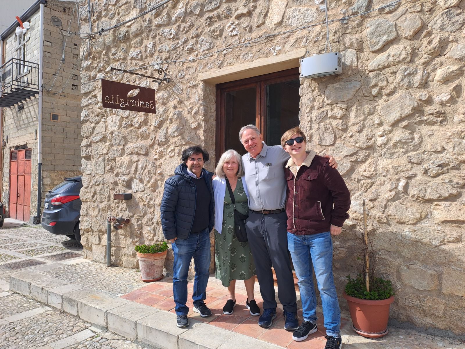 A family posing outside the stone house their ancestors left