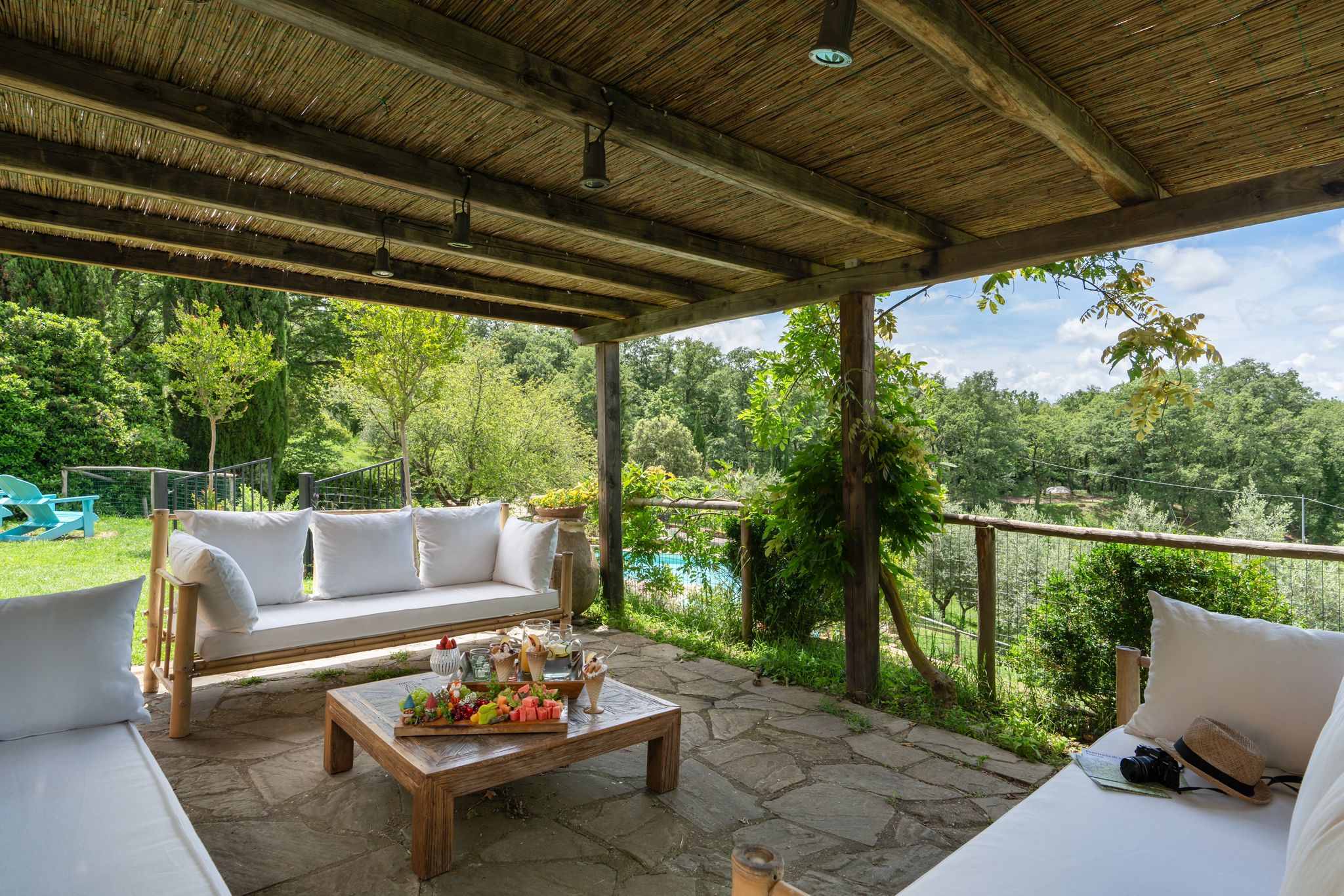 A covered terrace with sofas looking out over the Tuscan countryside