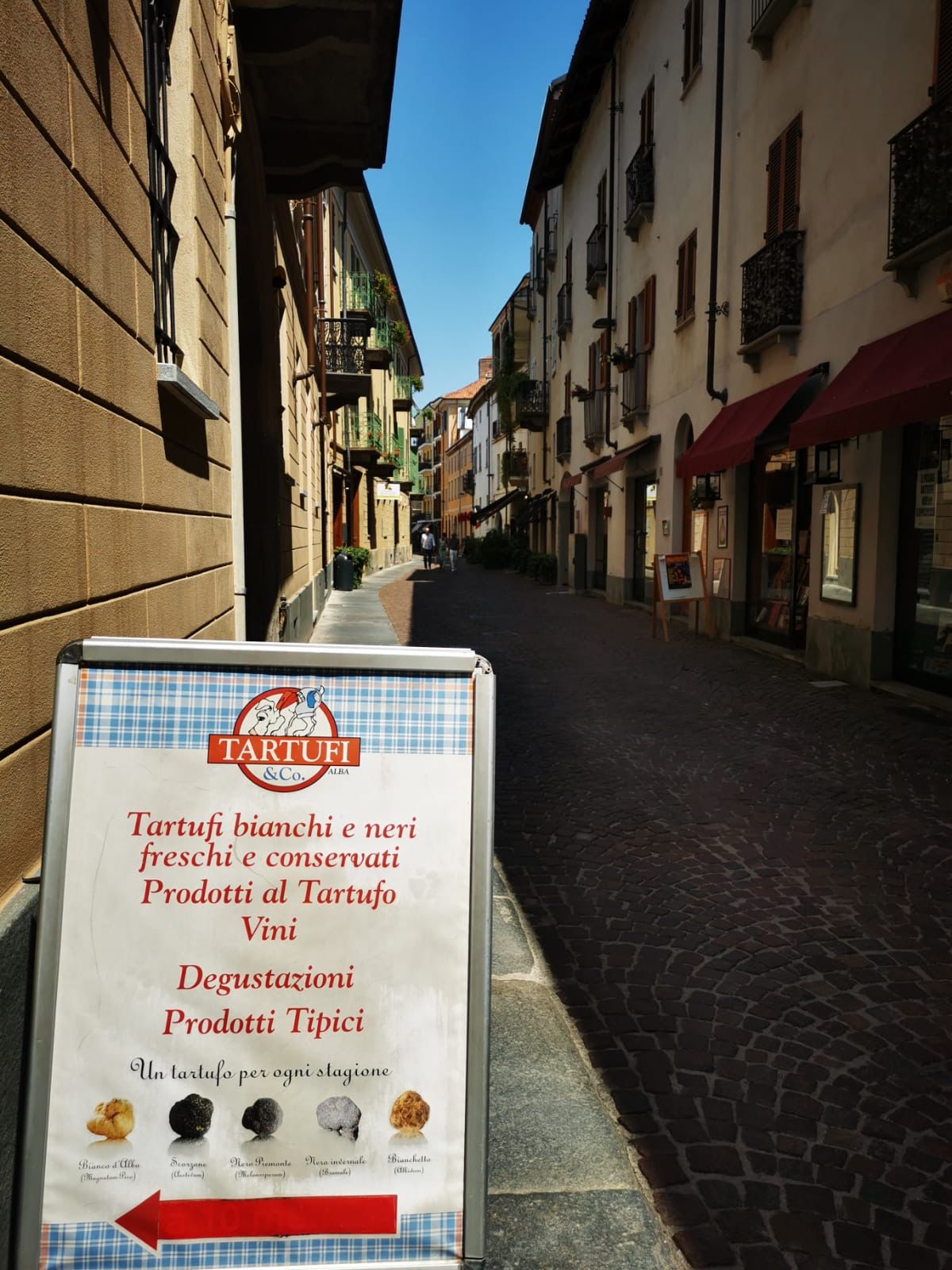 A truffle shop sign on a narrow street in a Piedmontese town