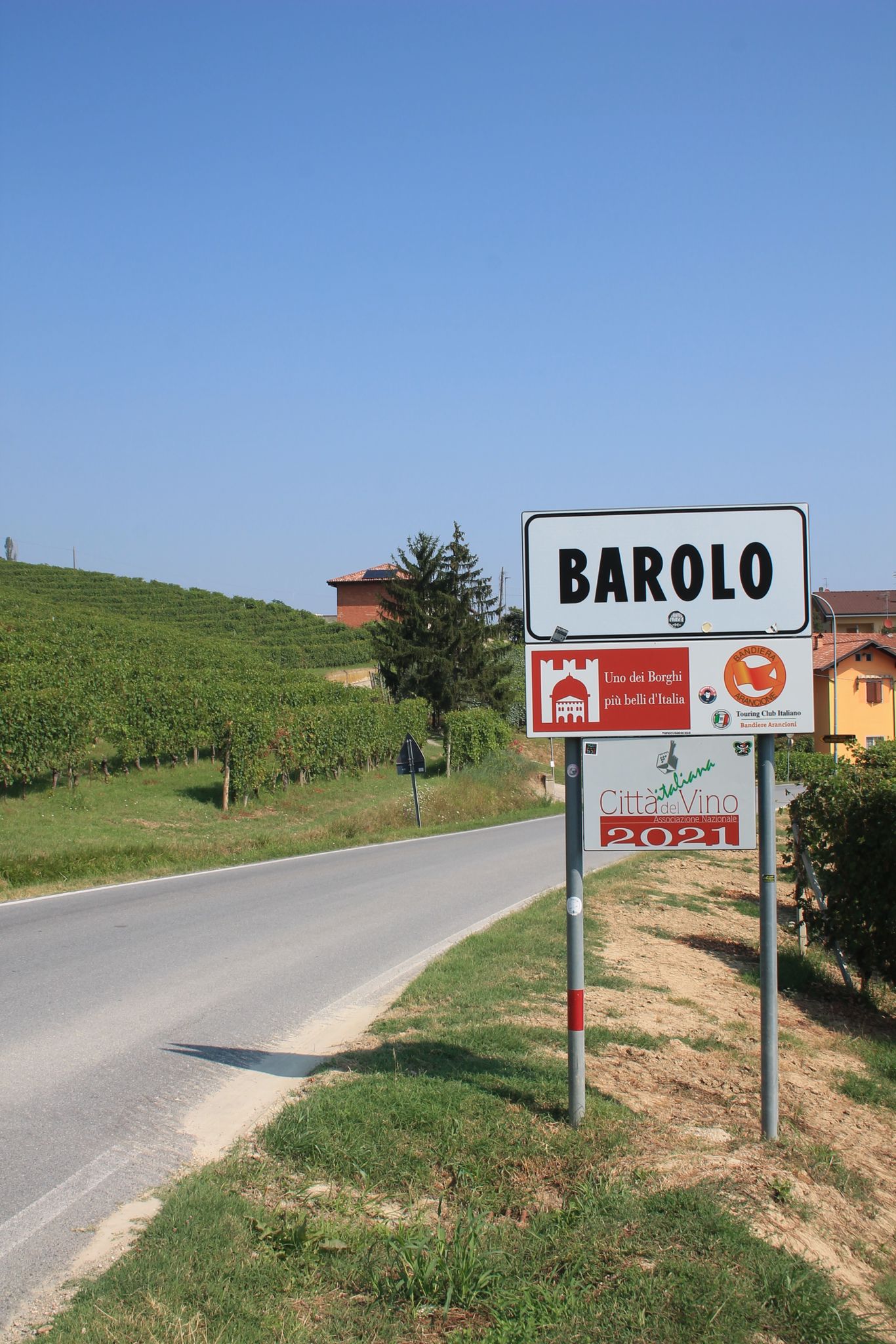 The road sign at the entrance to Barolo, vineyards behind it