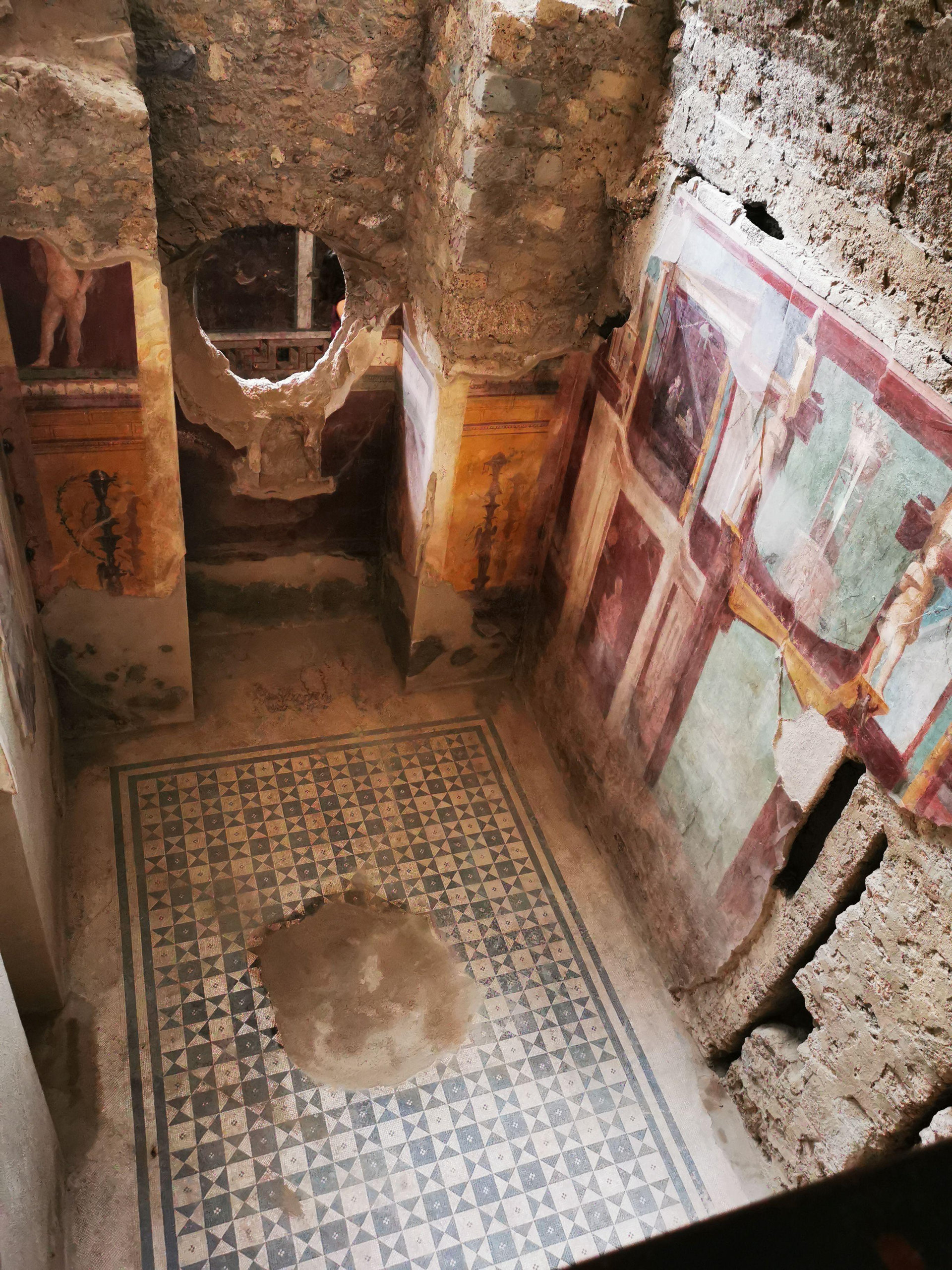 A frescoed room with a mosaic floor in the House of Thiasos at Pompeii