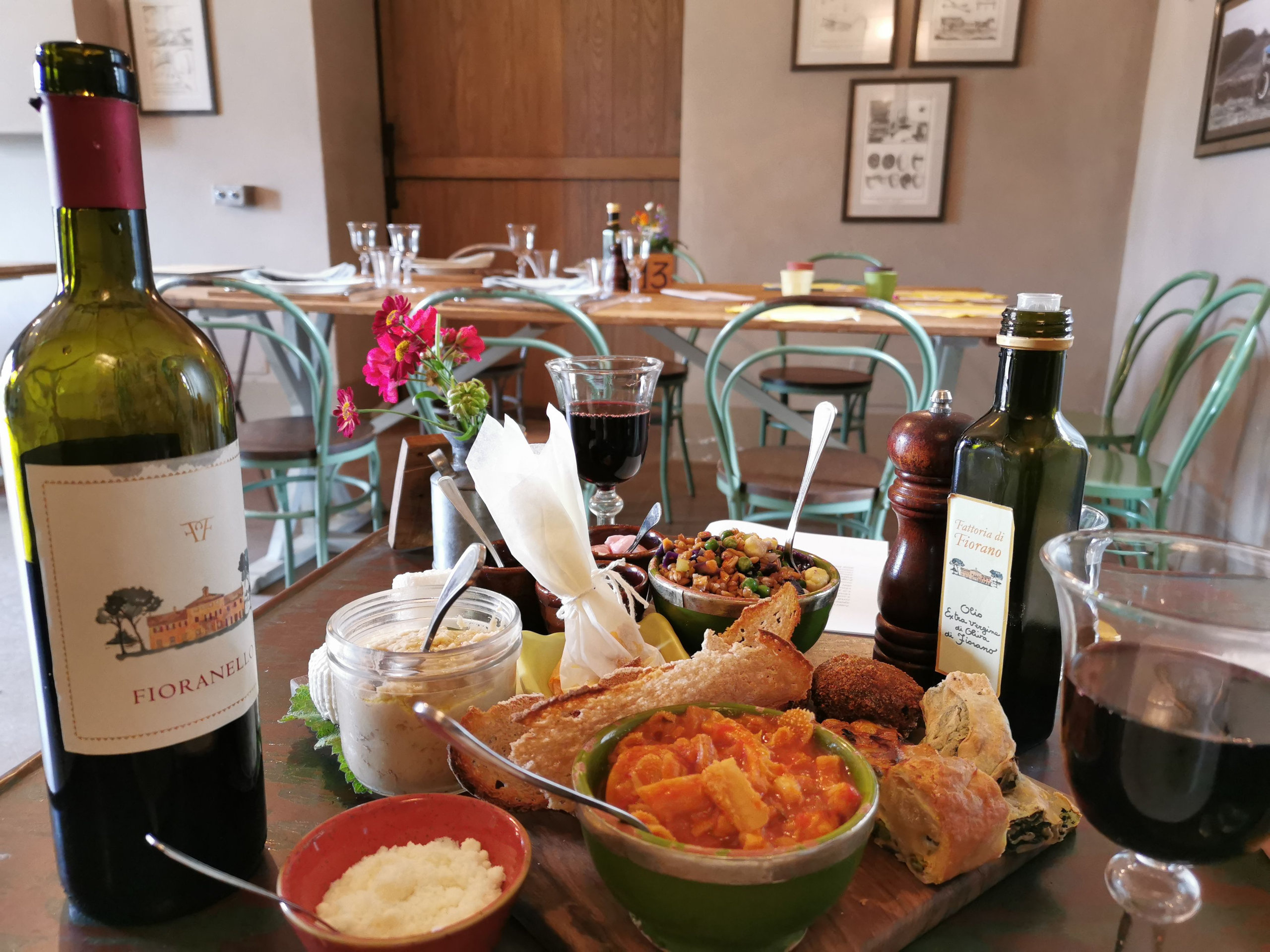 A trattoria table laid with local dishes, bread and red wine