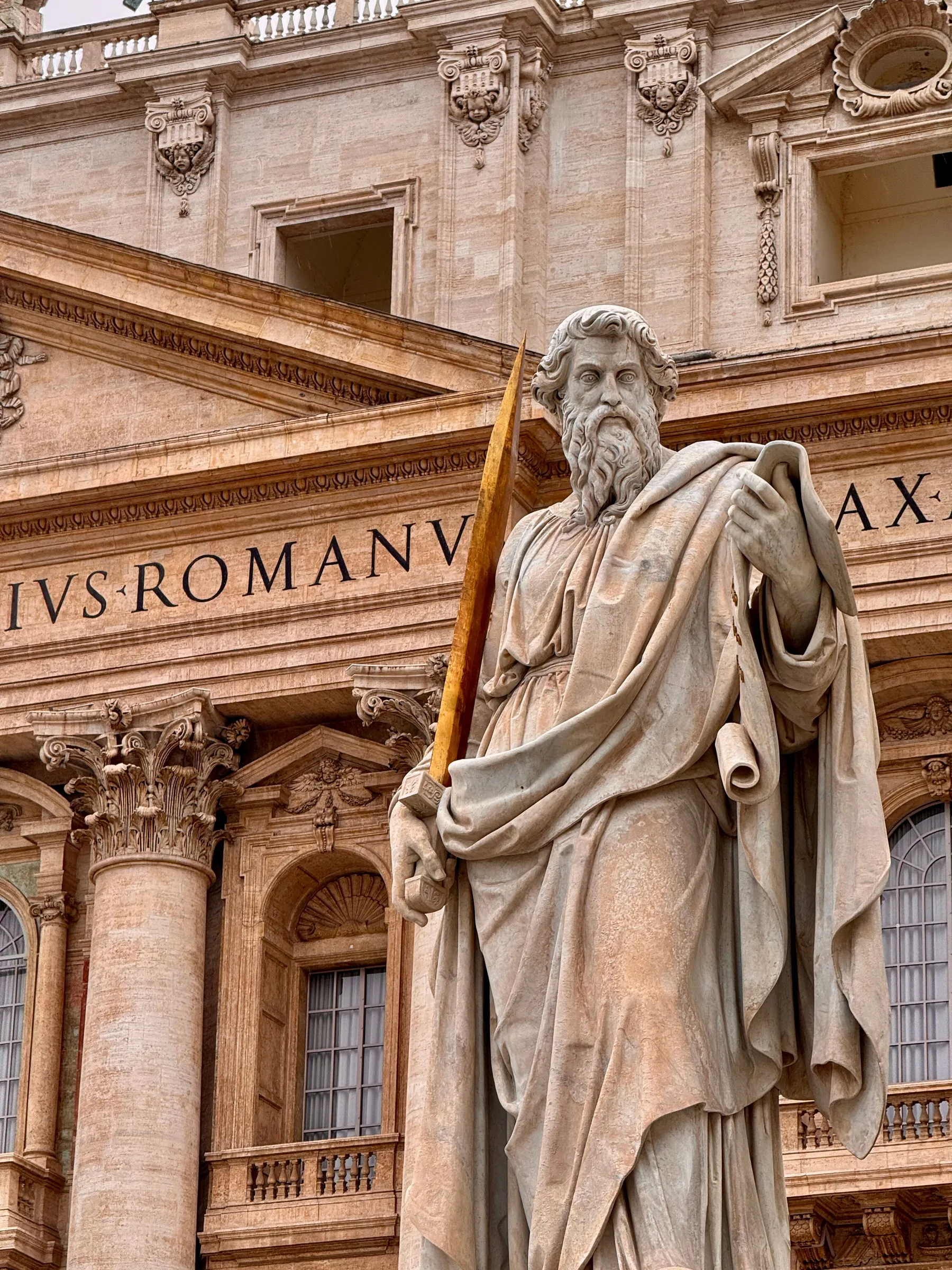 The statue of Saint Paul in front of the façade of St. Peter's Basilica