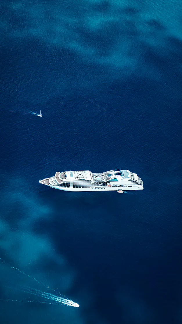 A cruise ship seen from above, anchored on deep blue sea