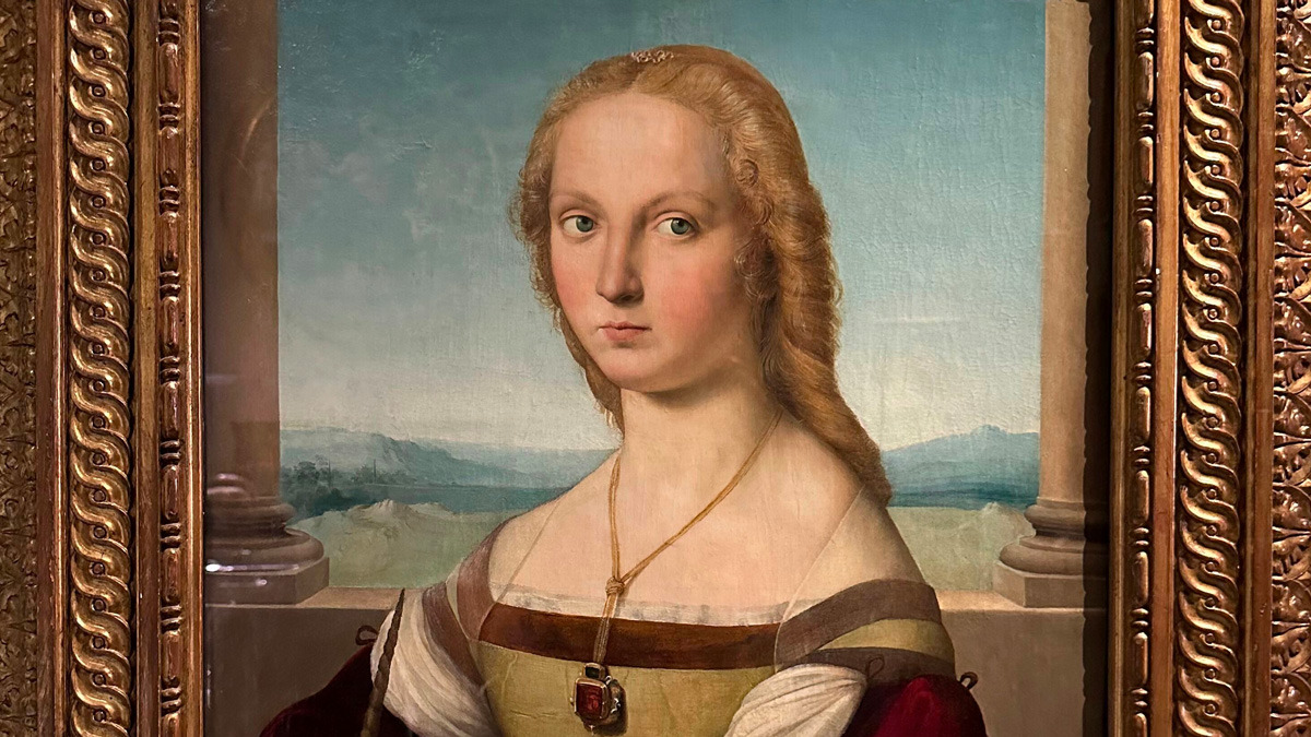 Renaissance portrait of a young woman with golden hair and a ruby pendant, in a carved gilt frame