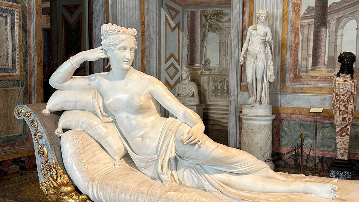 Neoclassical marble statue of a woman reclining on a gilded chaise longue, with other statues beyond