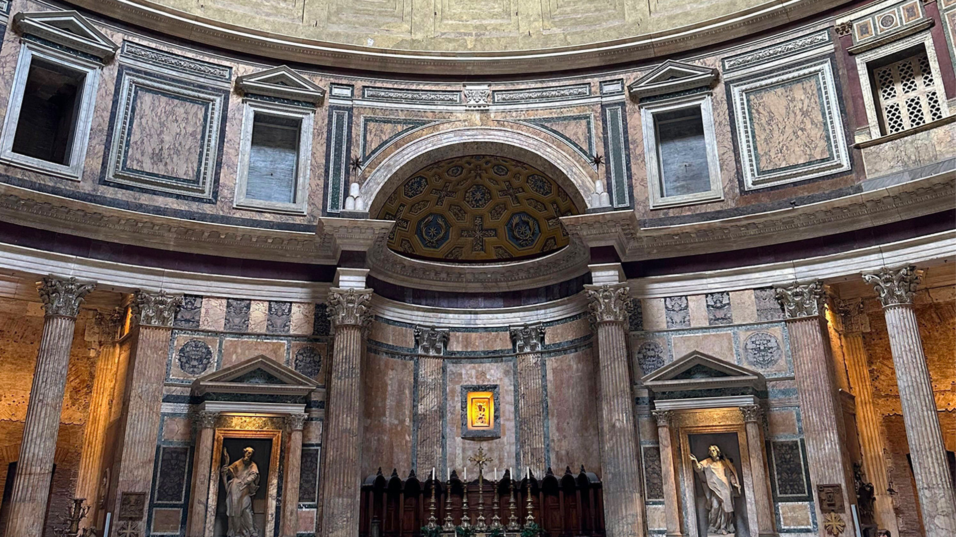 Interior of the Pantheon with marble-clad walls, columns, altar niche and coffered ceiling
