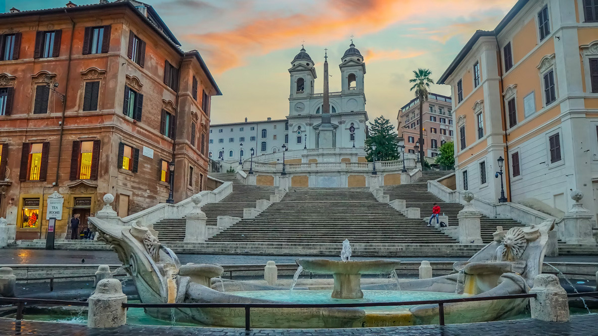 Spanish Steps rising to Trinità dei Monti at sunset, with the Barcaccia fountain in the foreground