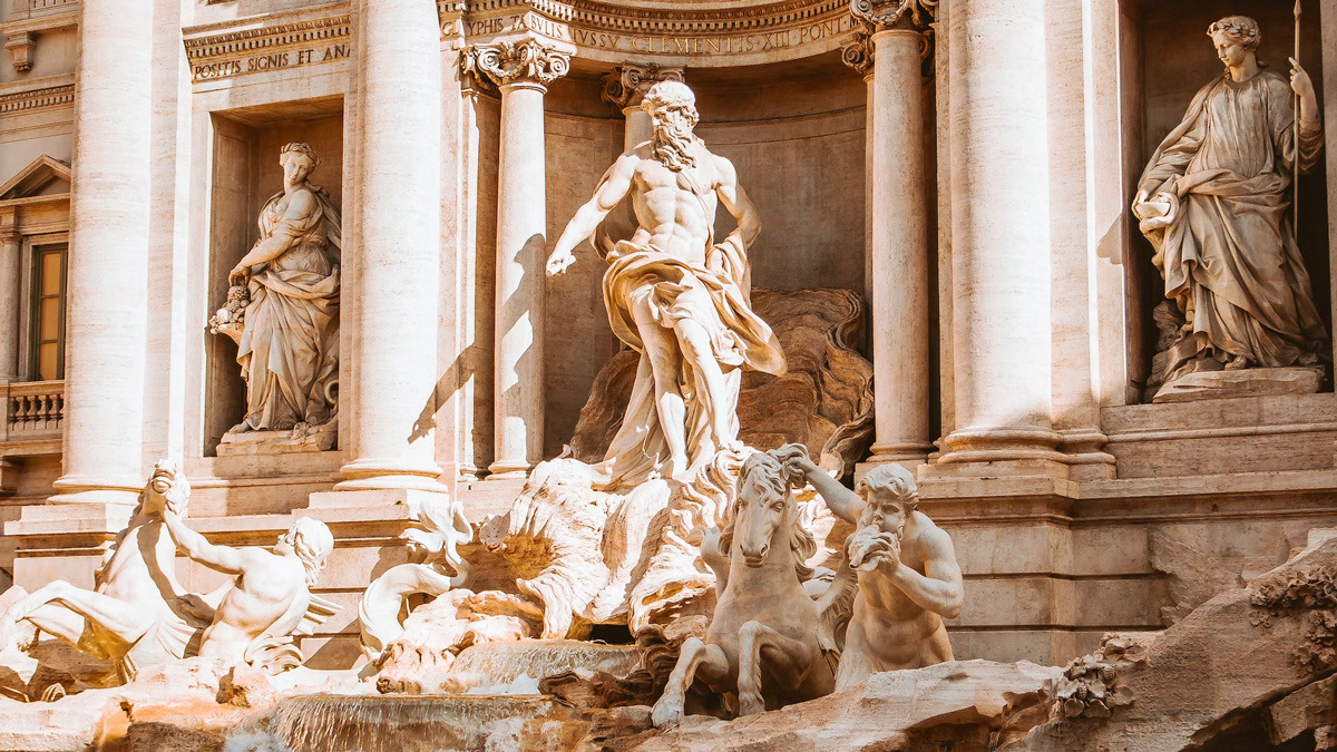 Central sculptural group of the Trevi Fountain in warm sunlight