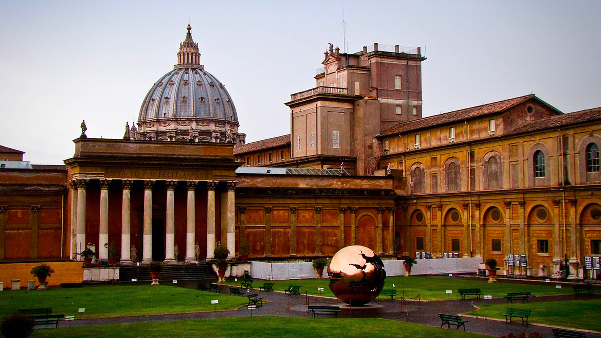 Vatican gardens courtyard with a bronze sphere sculpture and the dome of St Peter's behind