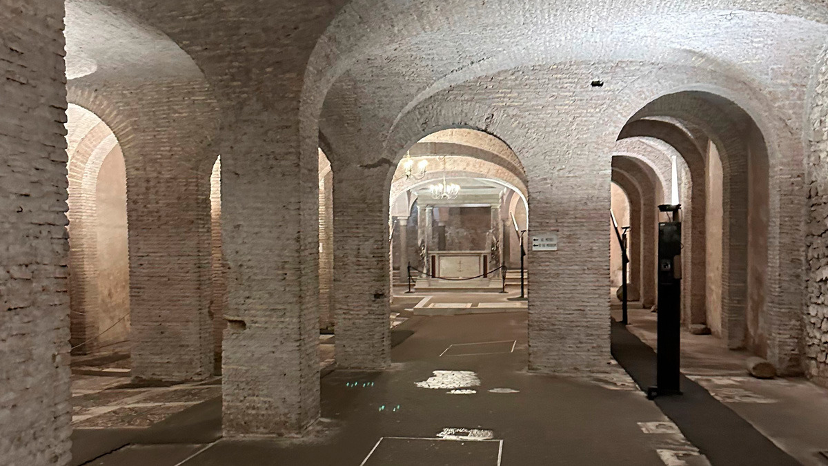 Vaulted brick chambers of an ancient Roman underground site lit by soft lights
