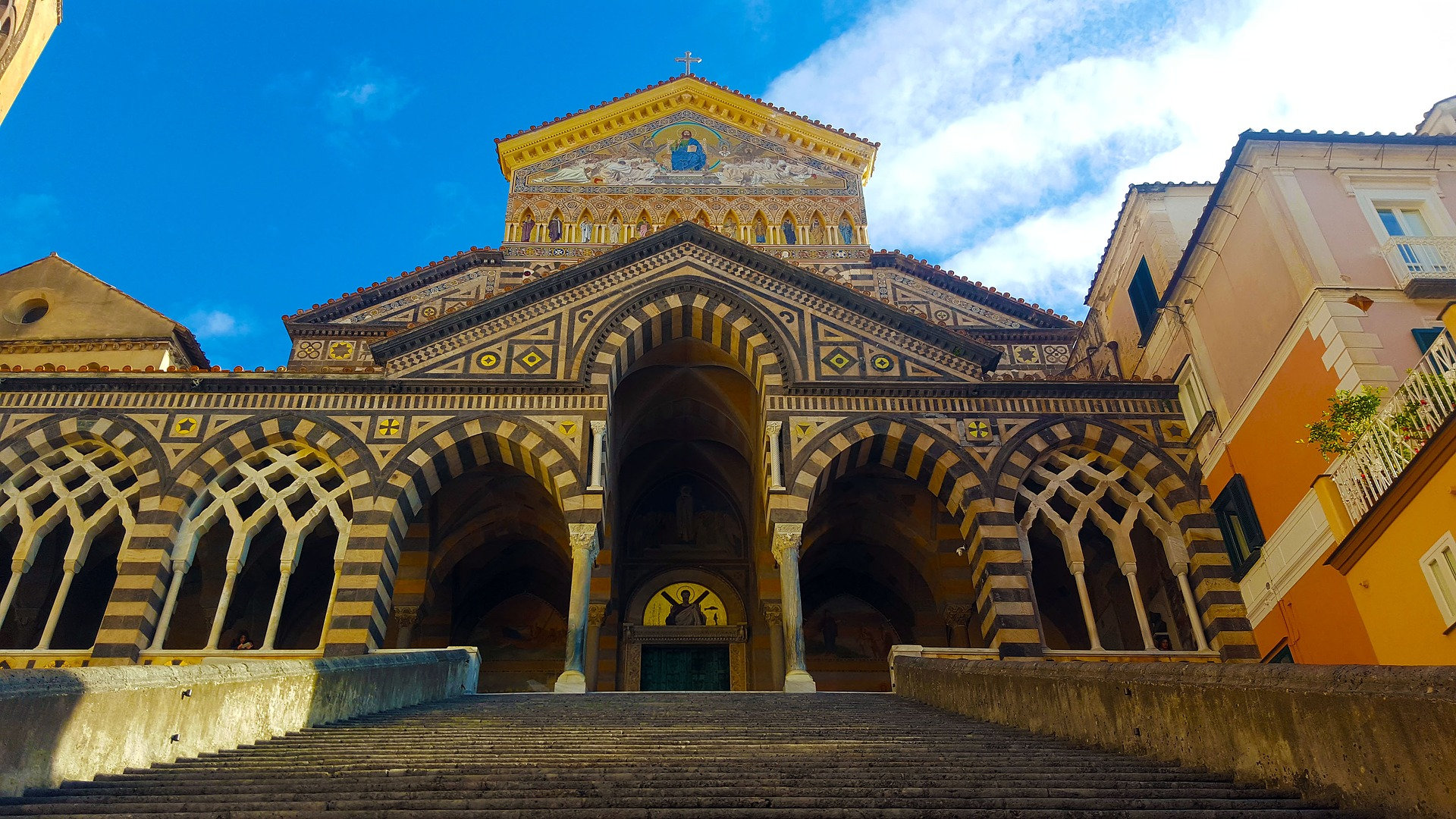 Striped arches of Amalfi cathedral's facade rising above a wide flight of steps