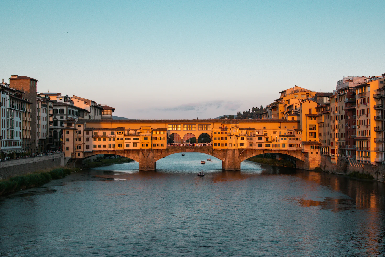 Ponte Vecchio and riverside houses glowing golden in the evening light