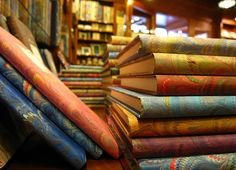 Stacks of books with marbled paper covers on the shelves of a bookbinder's shop