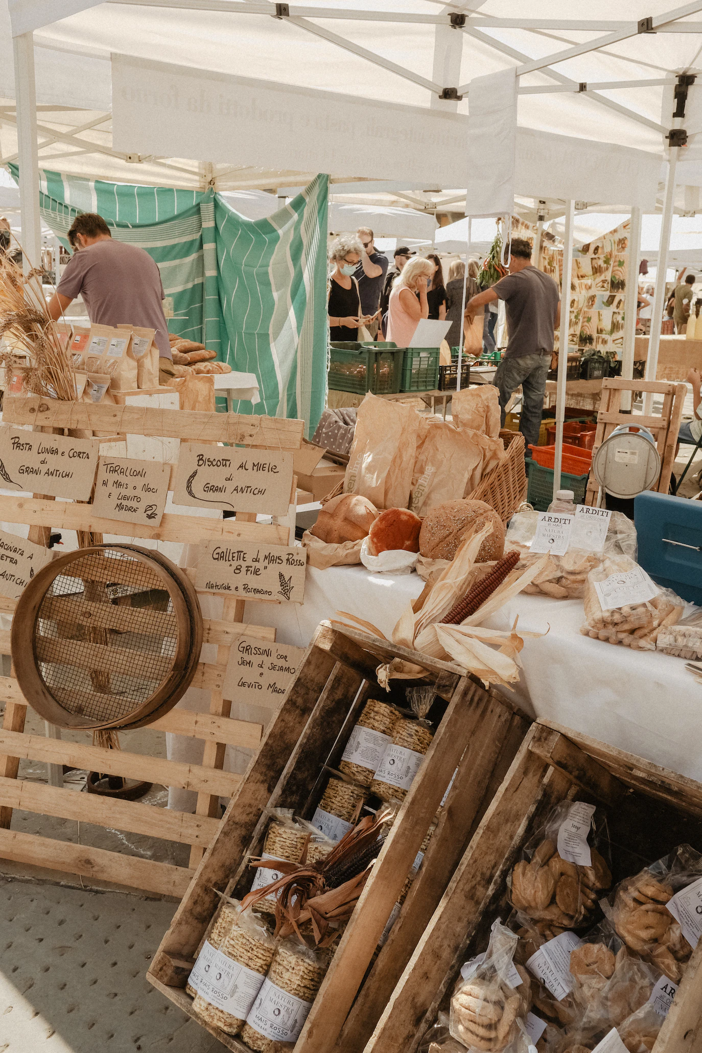Market stall with wooden crates of dried goods, fresh bread and hand-written signs