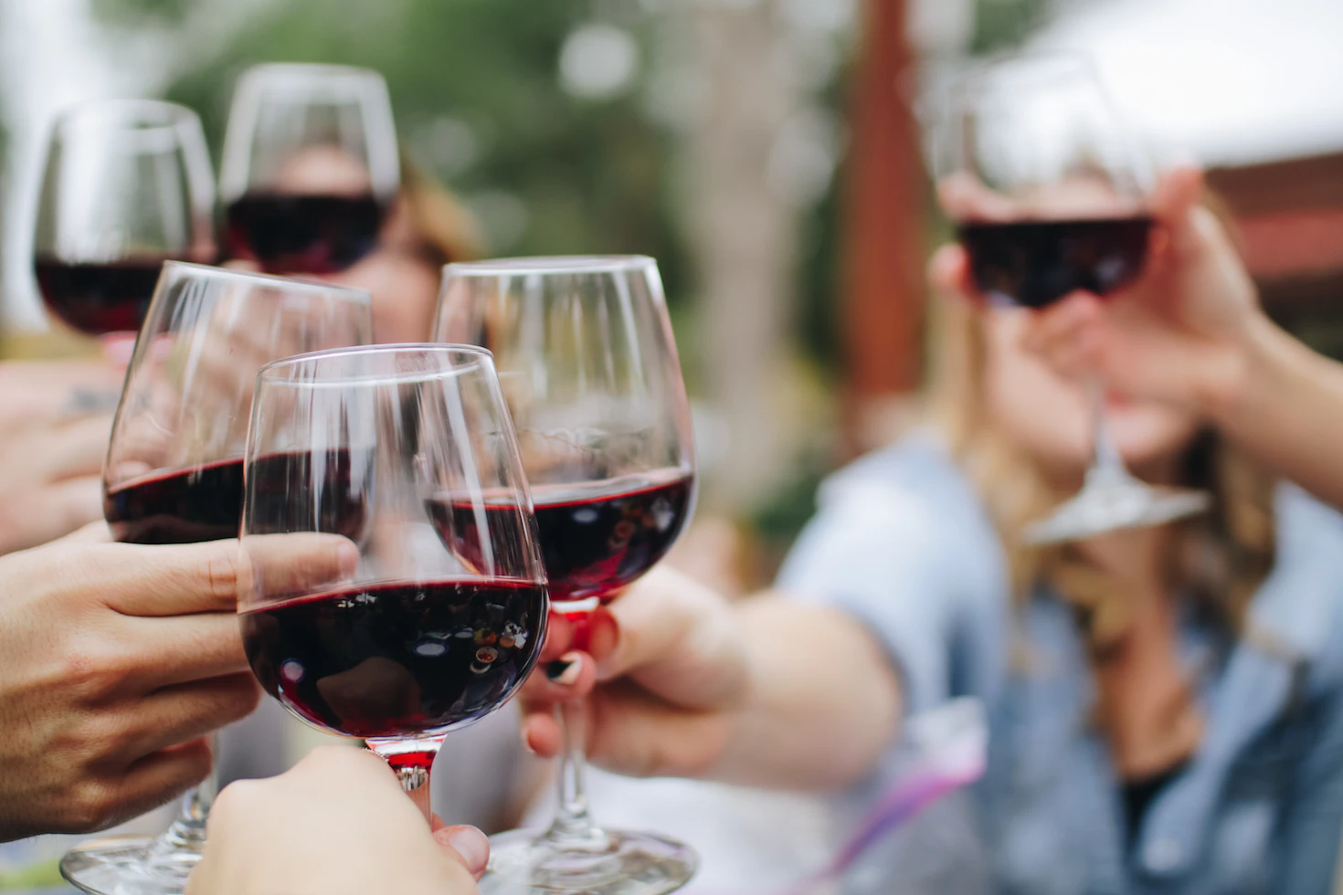 Friends toasting with glasses of red wine outdoors