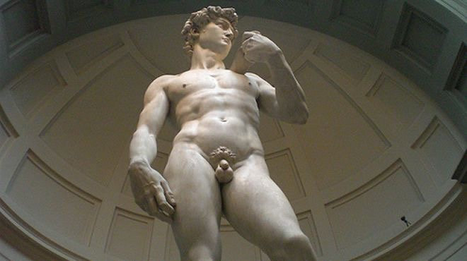 Michelangelo's David marble statue seen from below beneath the domed ceiling of the Accademia Gallery