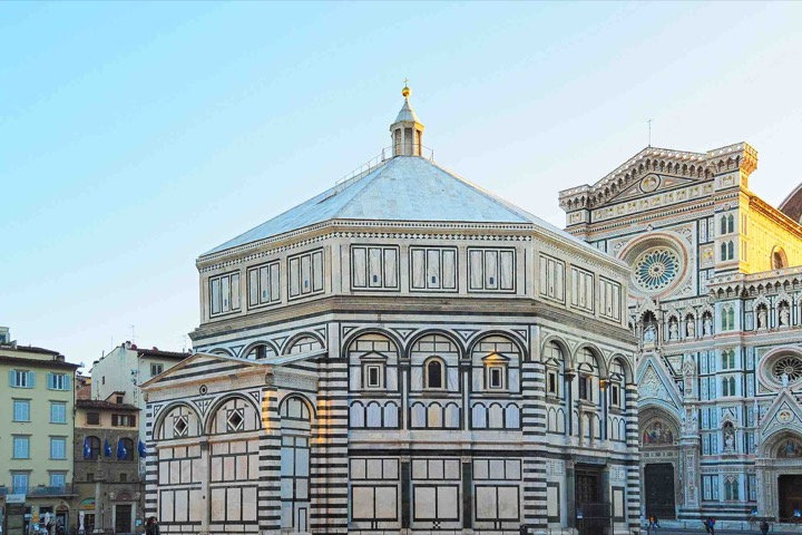 Octagonal Florence Baptistery in white and green marble beside the Cathedral facade