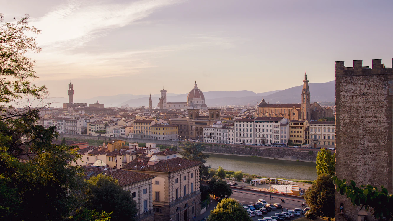 Evening view over Florence's rooftops with the Duomo and Palazzo Vecchio tower from a hillside terrace