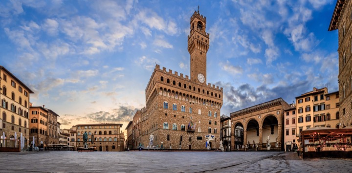 Wide view of Piazza della Signoria and the Palazzo Vecchio tower at sunrise