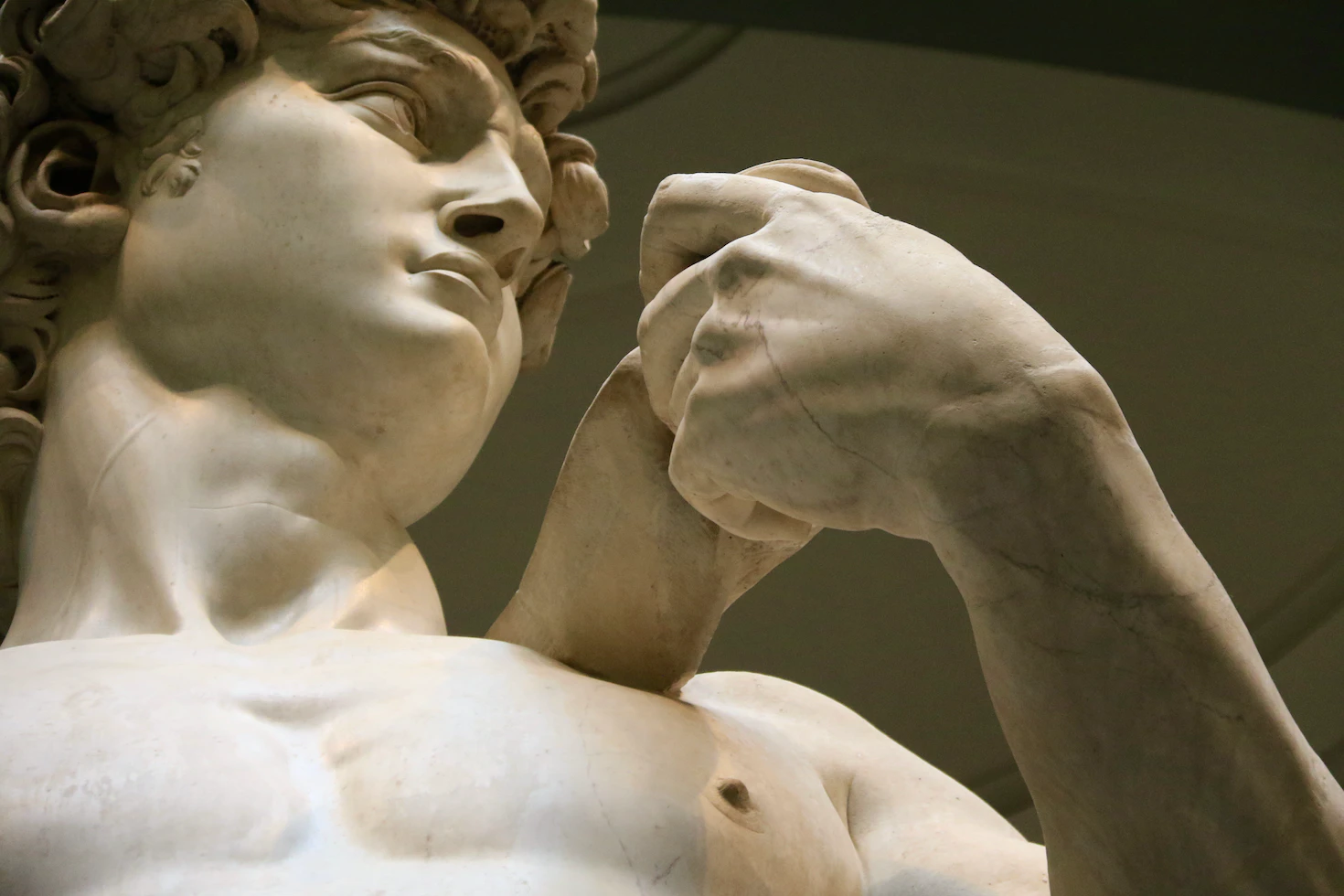 Close-up of Michelangelo's David, the face and raised hand in white marble