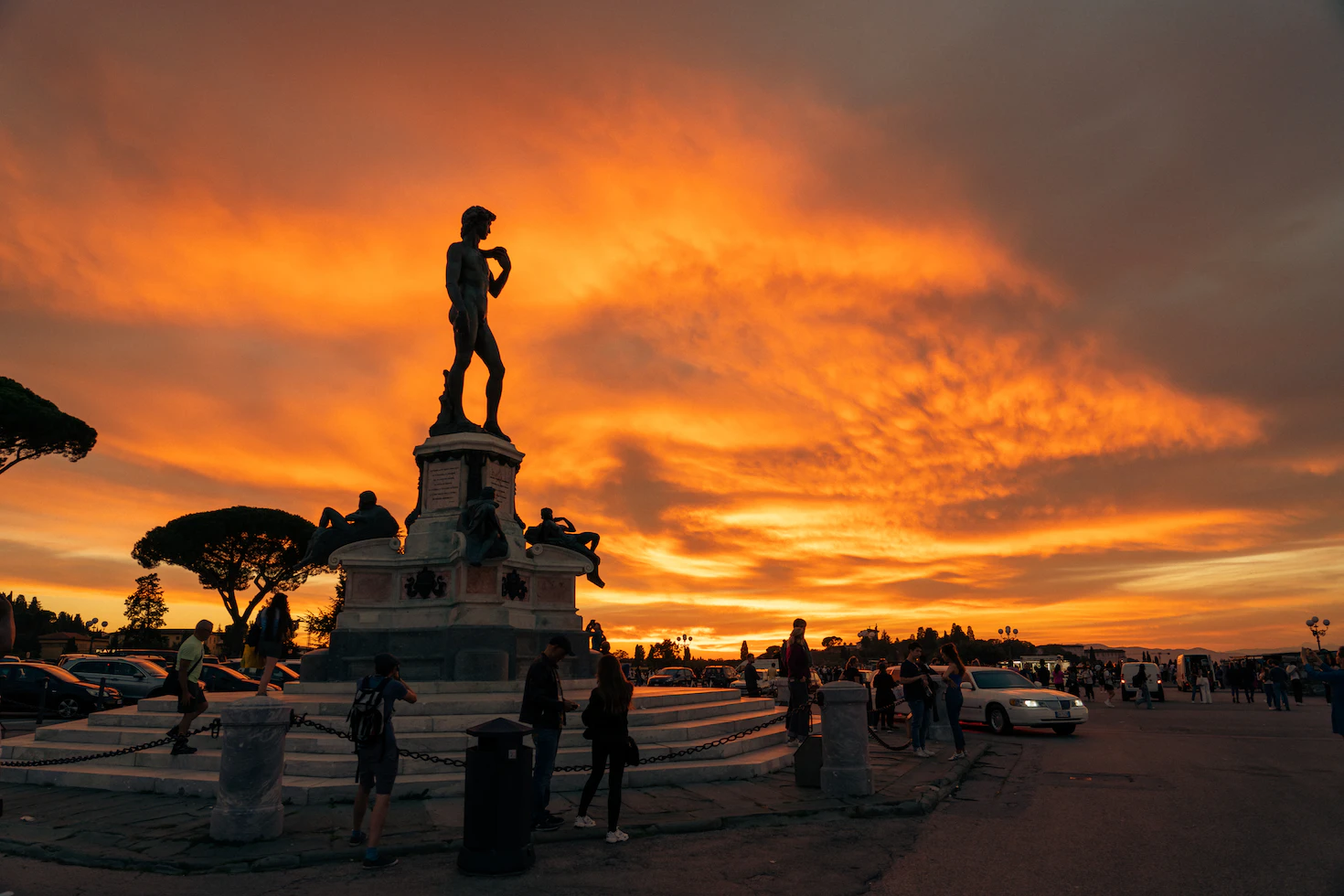Bronze copy of David silhouetted against a fiery orange sunset at Piazzale Michelangelo