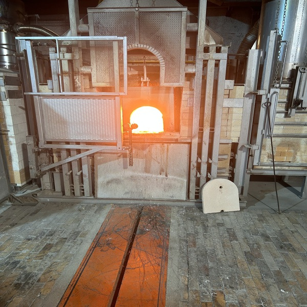 Glassmaking furnace with a glowing opening inside a workshop