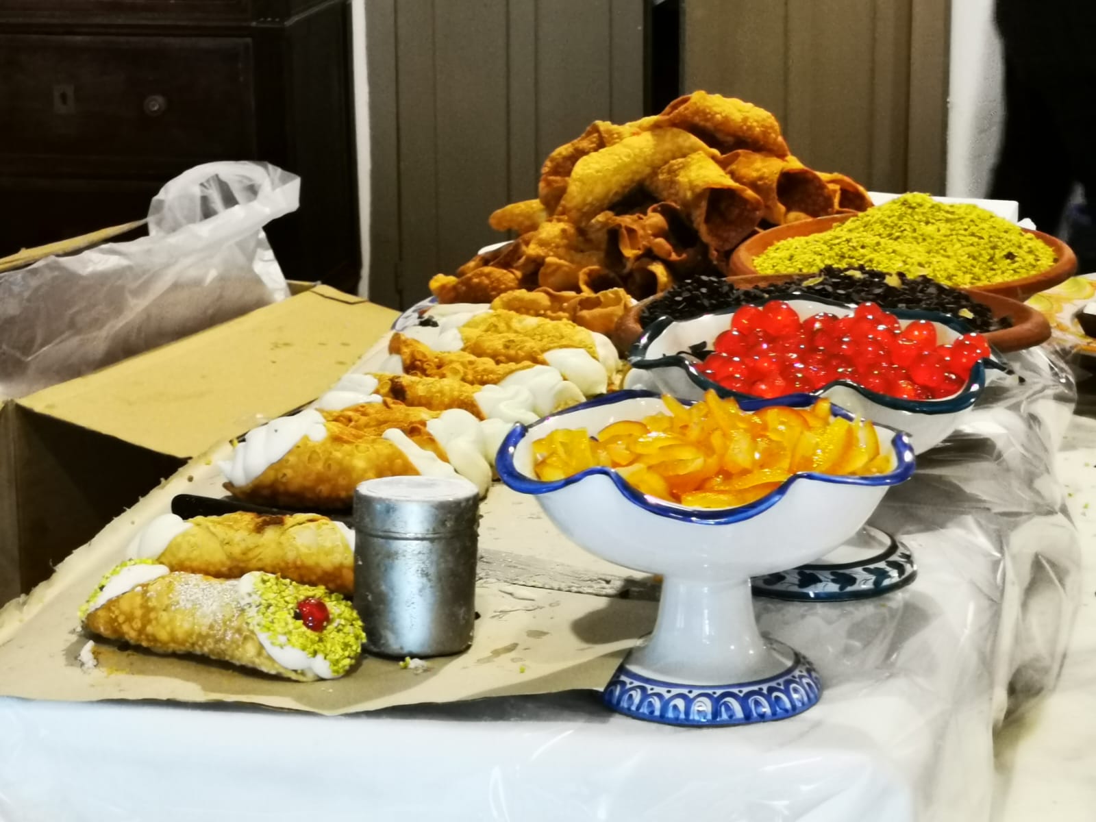 Table of Sicilian pastries with cannoli, fried sweets, candied orange and pistachio