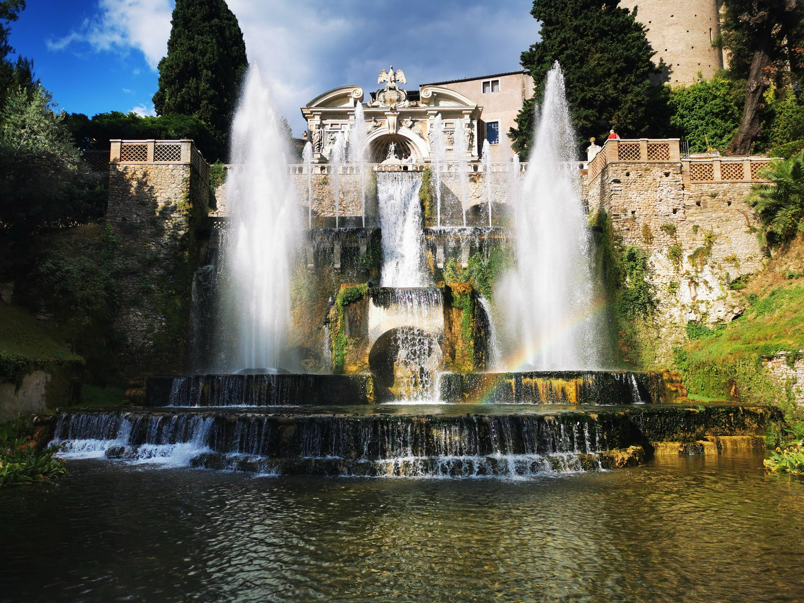 Cascading fountains and jets of water in the gardens of Villa d'Este in Tivoli, with a faint rainbow