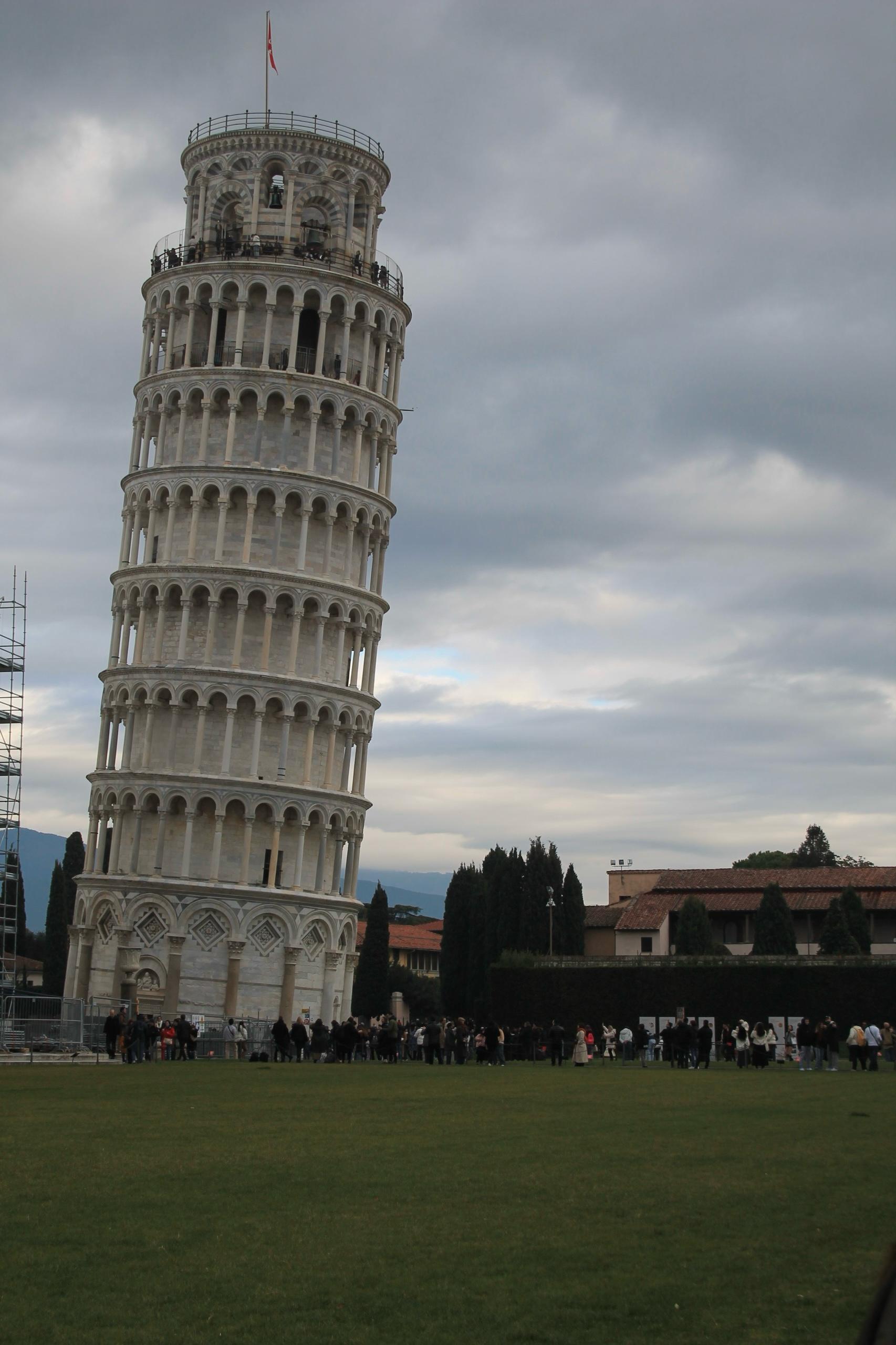 Leaning Tower of Pisa rising above a lawn under a cloudy sky