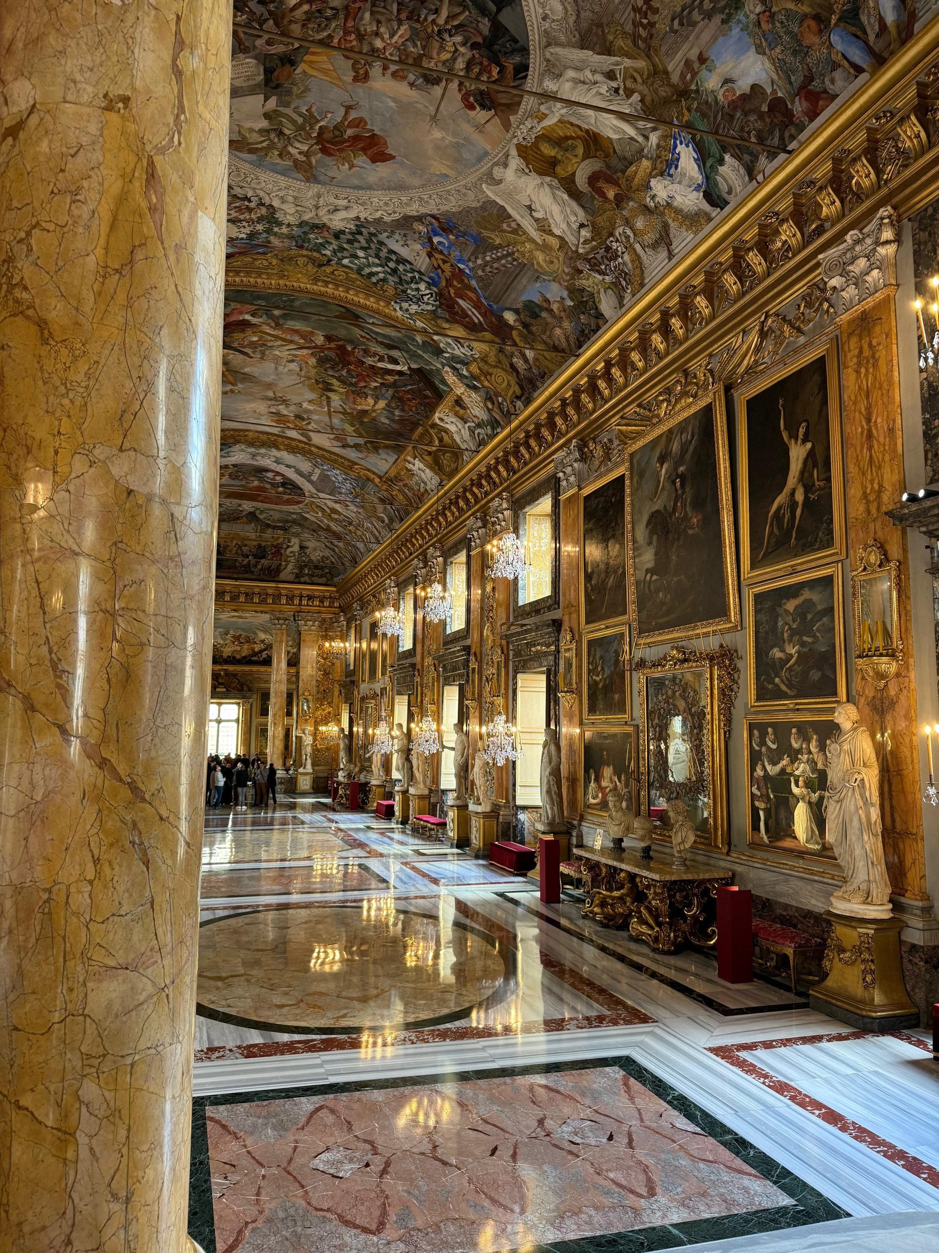 Grand gallery with a gilded frescoed vault, marble columns and a polished mosaic floor at Palazzo Colonna