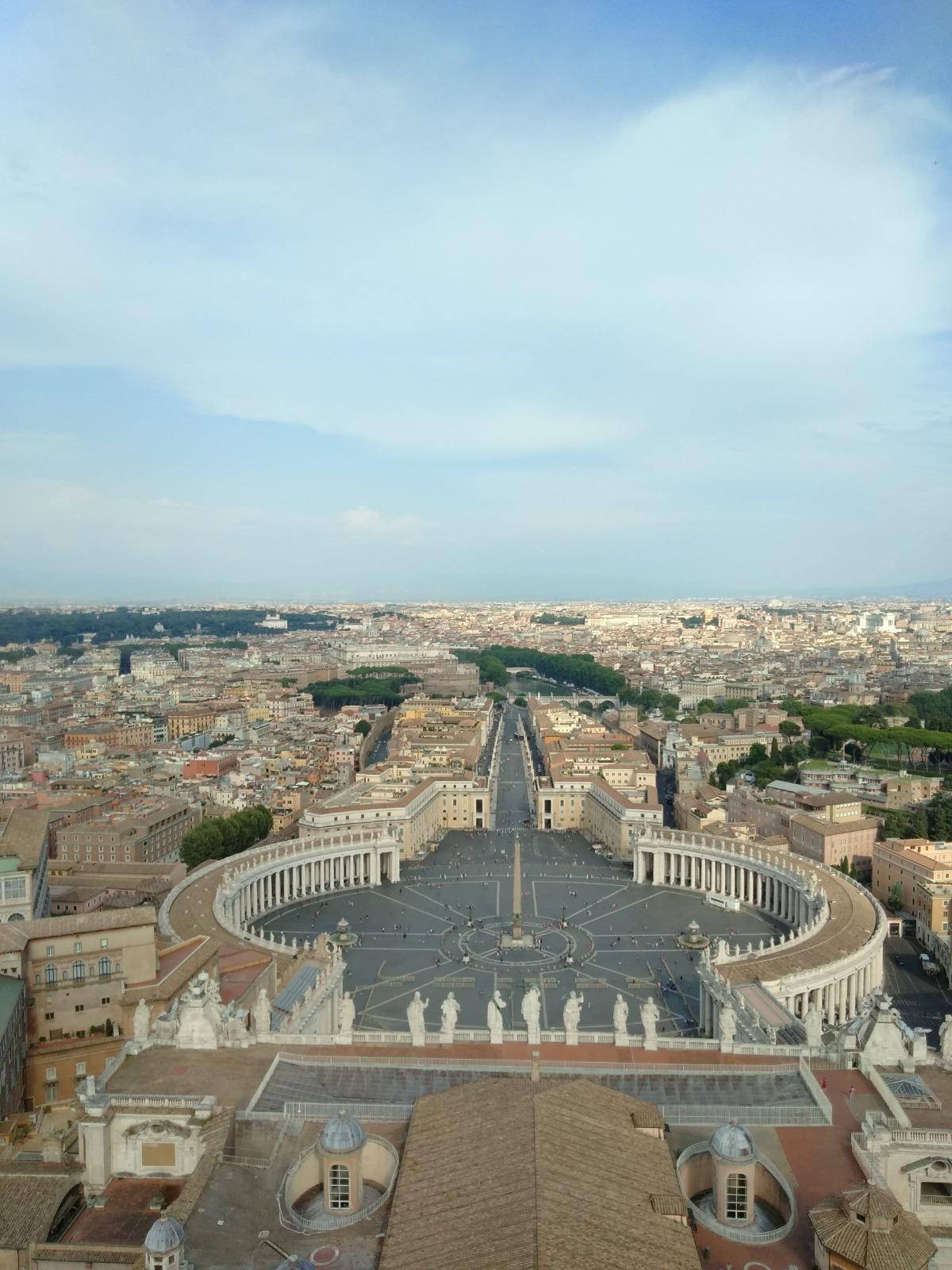 View from the dome over Saint Peter's Square, its curved colonnades and the city beyond