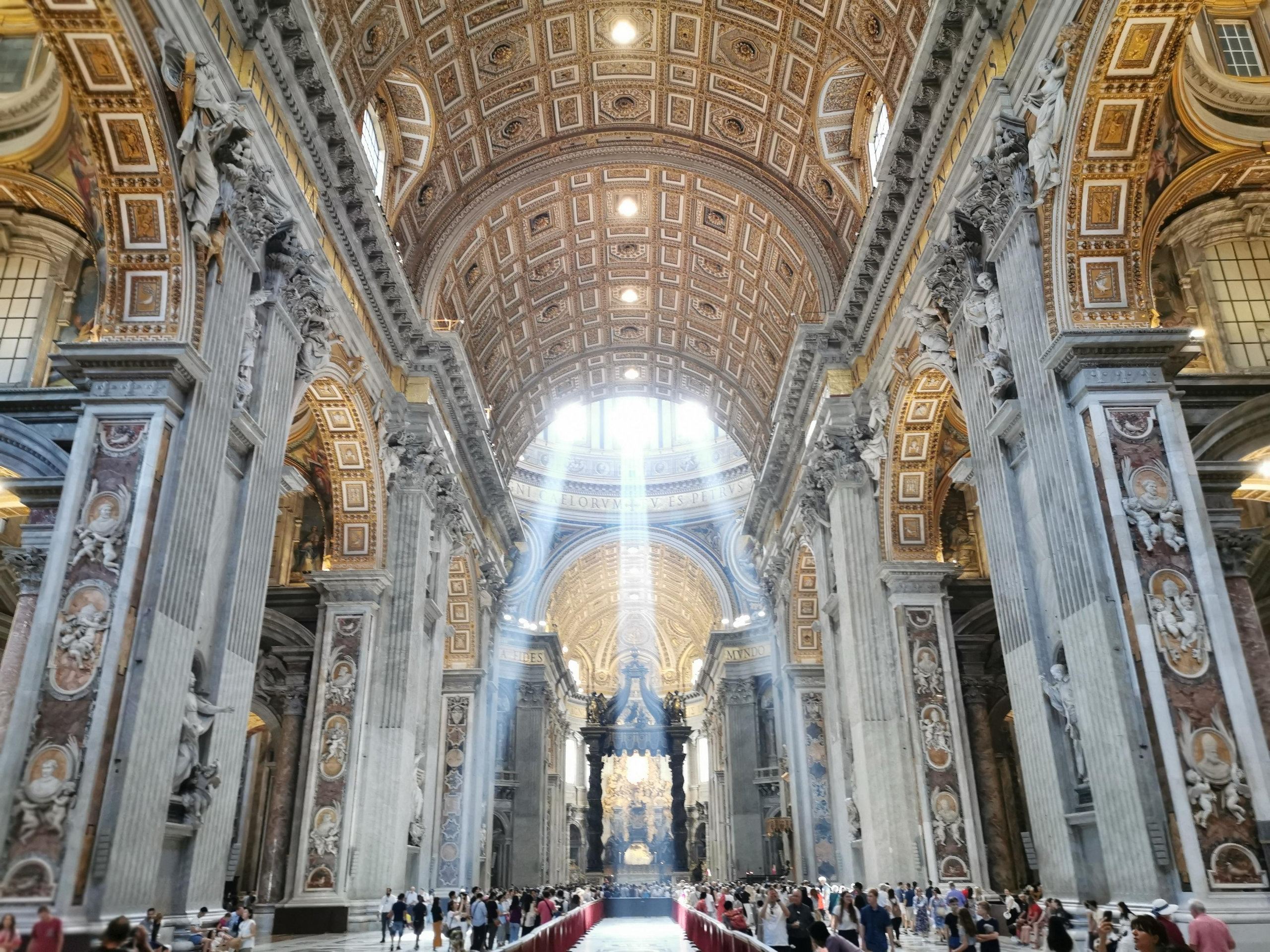 Nave of Saint Peter's Basilica with a coffered vault and light streaming down towards the baldachin