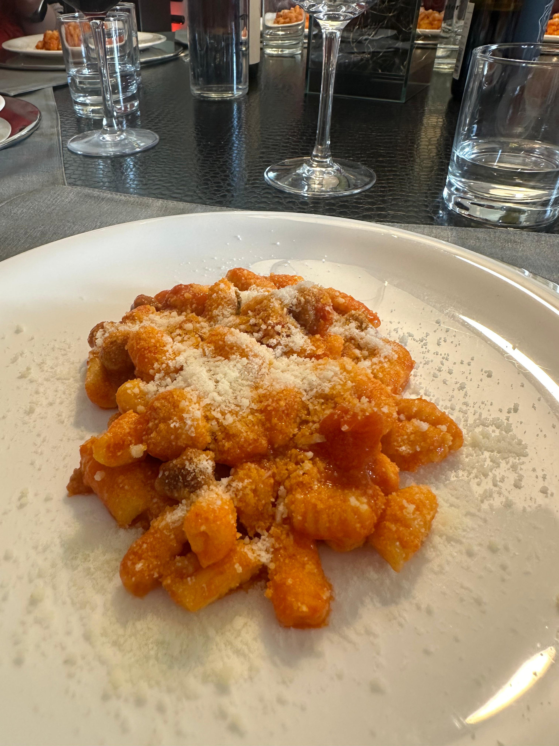 Plate of potato gnocchi in tomato sauce dusted with grated cheese