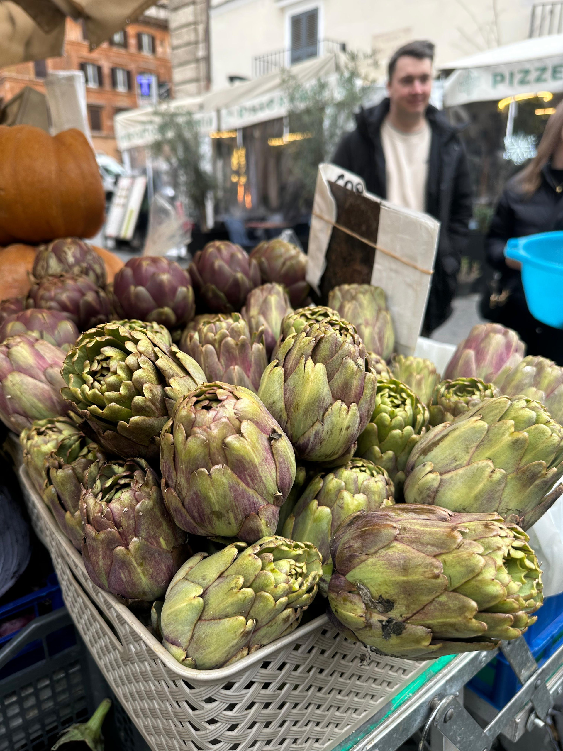 Basket of green and violet artichokes on a market stall in Rome