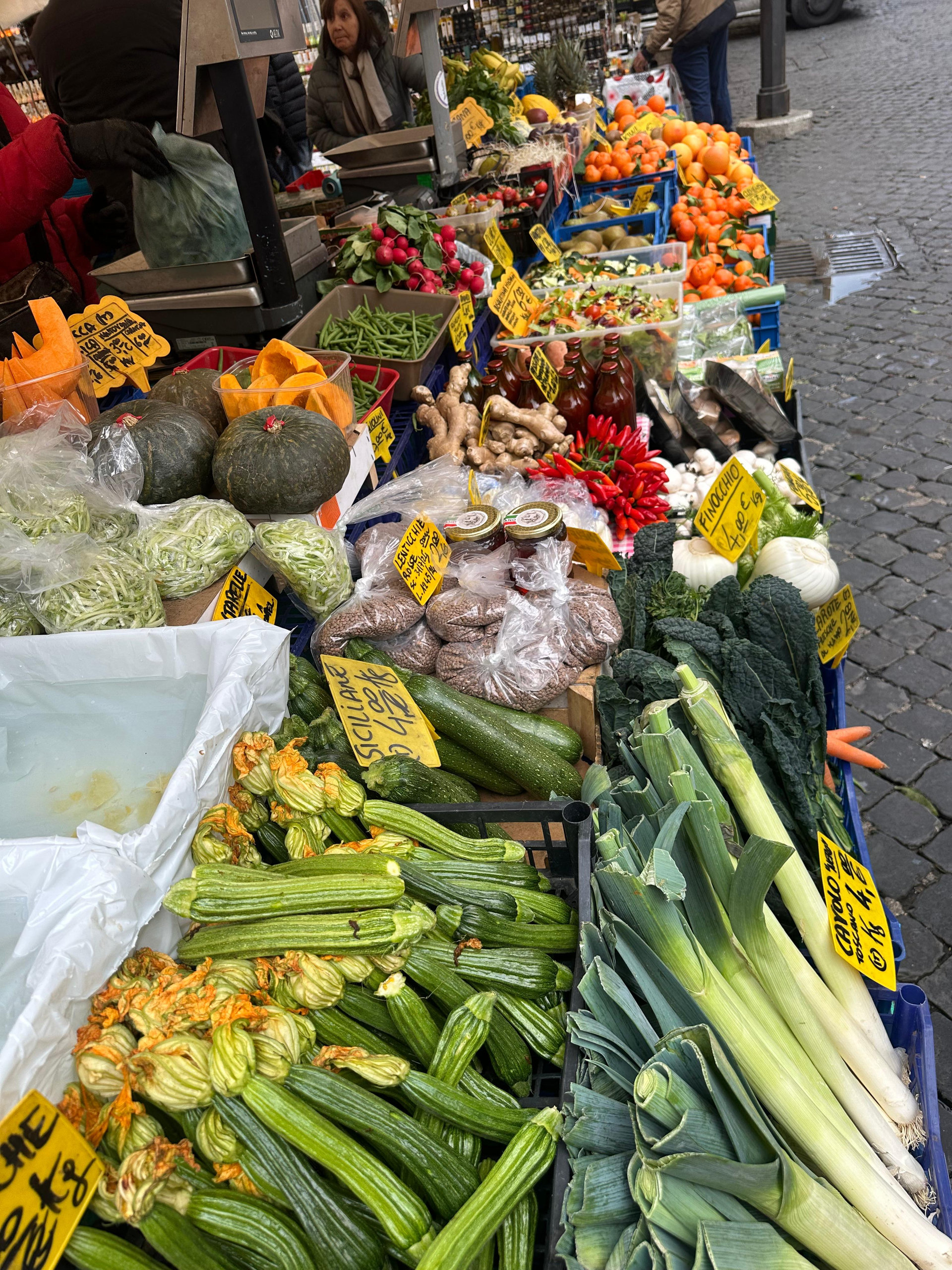 Market stall with courgettes and courgette flowers, leeks, squash and tomatoes
