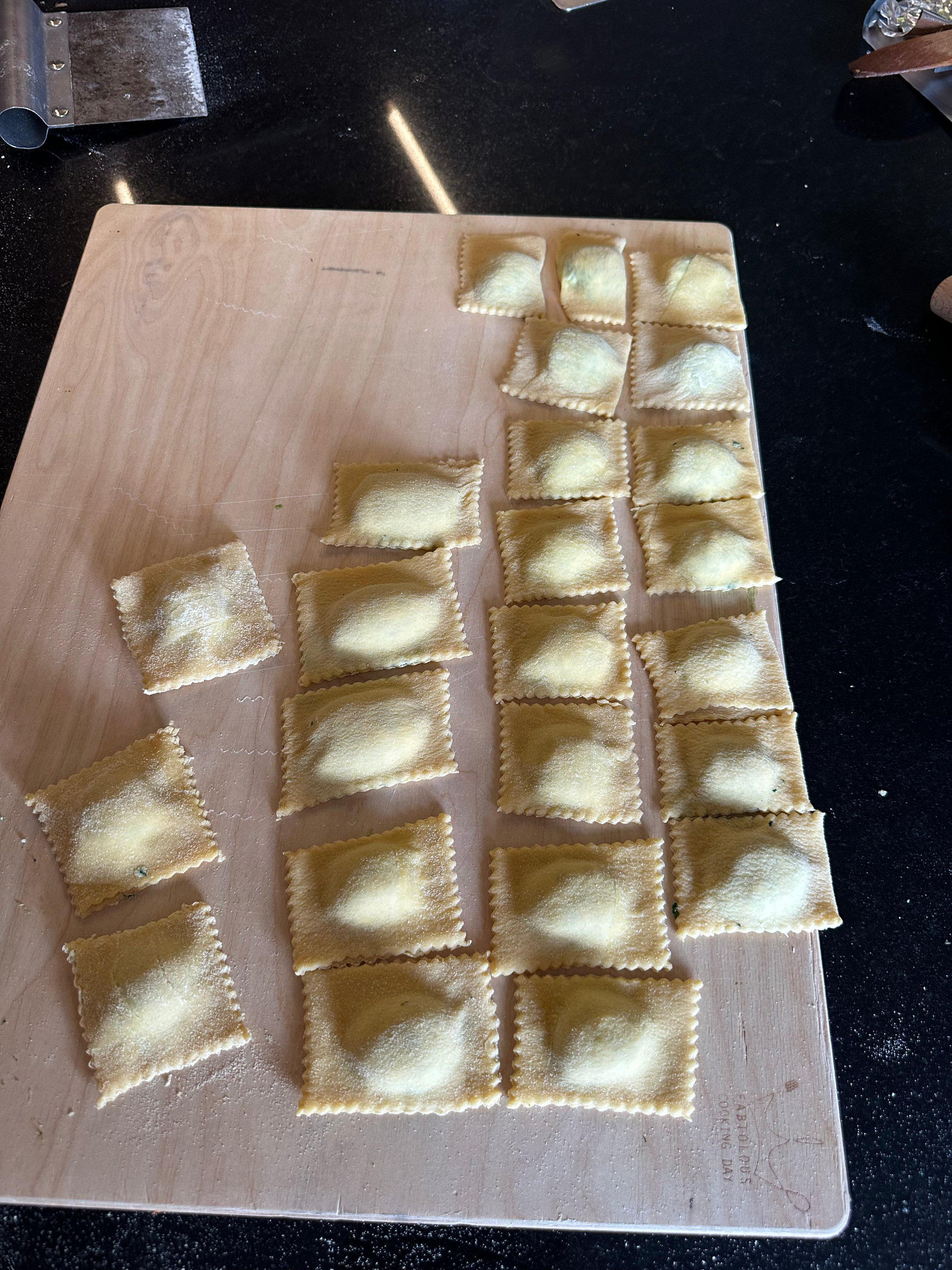 Freshly made ravioli arranged on a wooden board