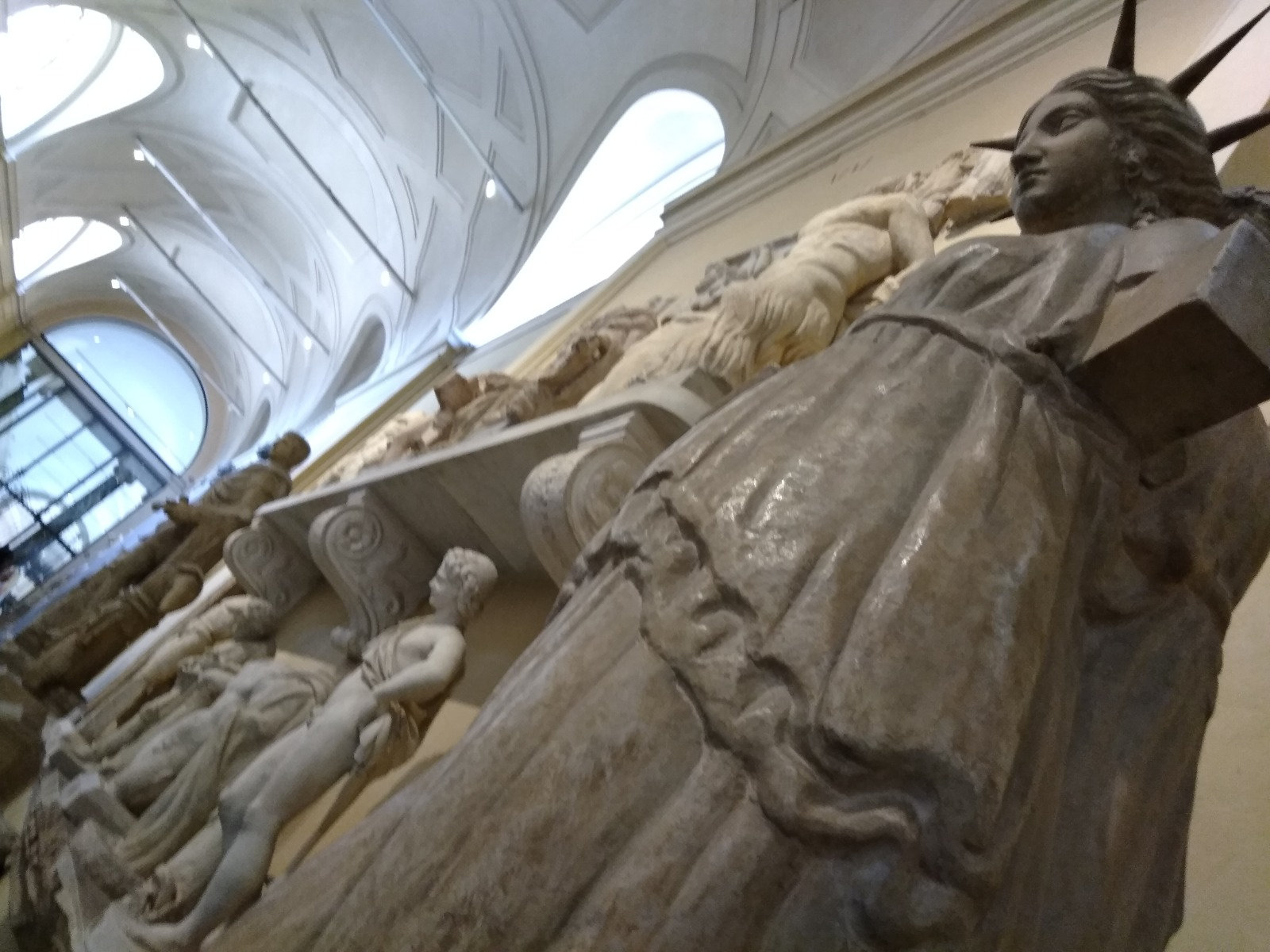 Classical marble and plaster statues in a bright vaulted gallery of the Vatican Museums