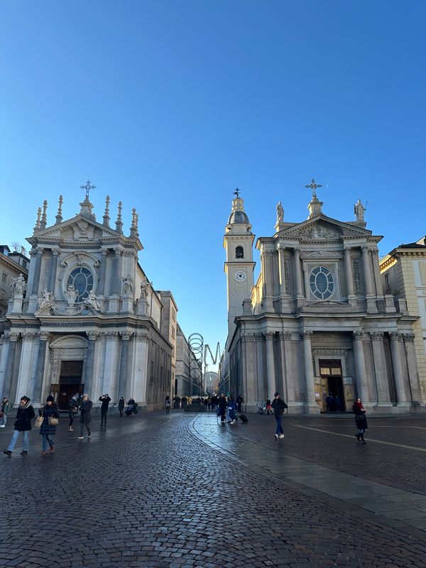 Twin Baroque churches facing each other across a cobbled square in Turin