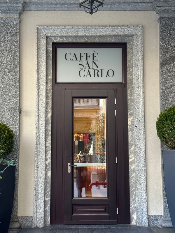 Caffè San Carlo entrance with a dark wooden door and granite frame