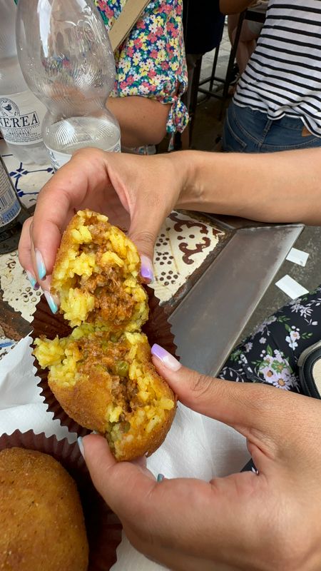 Arancino pulled open to show its rice and meat ragu filling