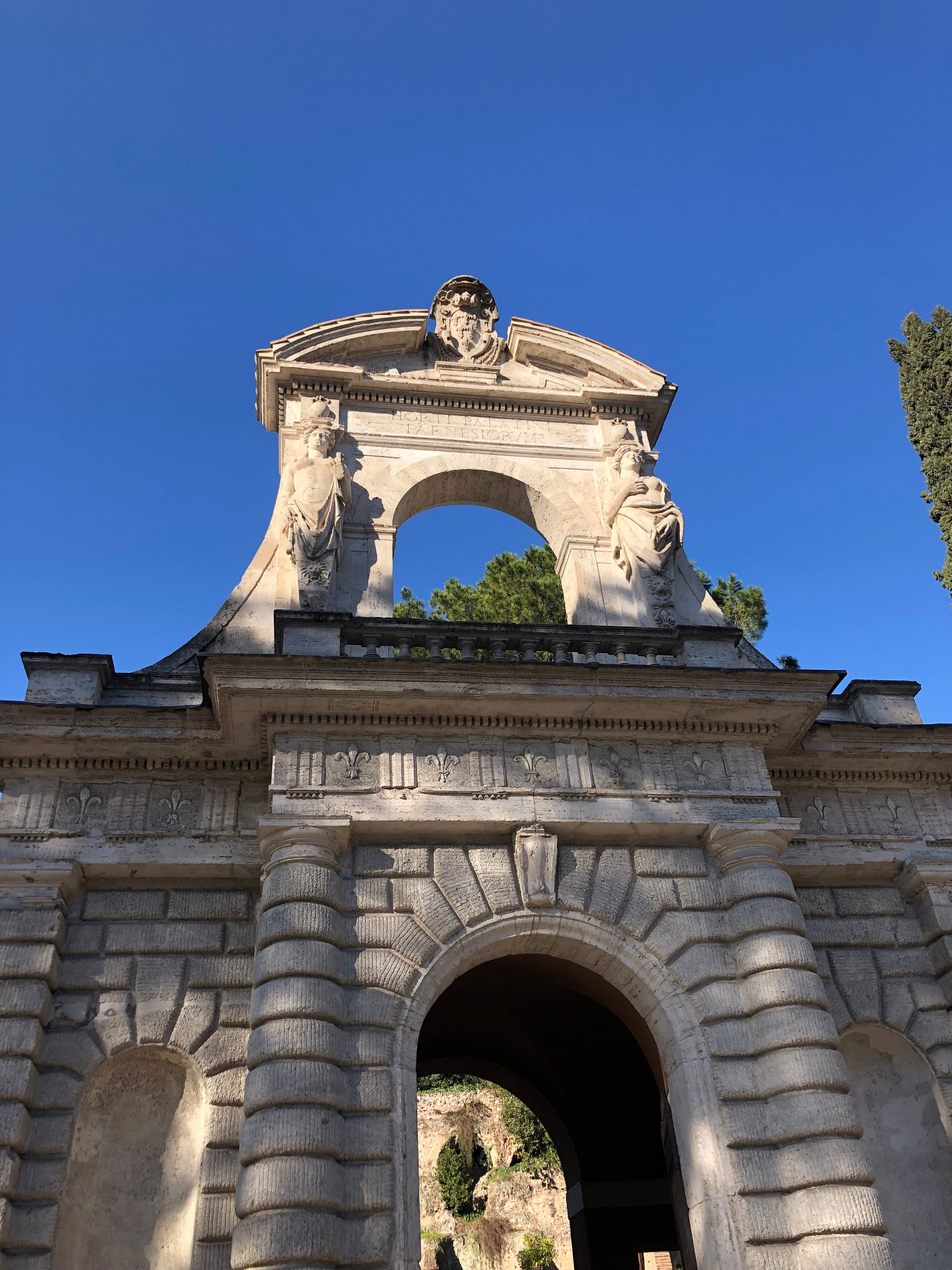 Carved stone gateway with sculpted figures and a crowning arch on the Palatine Hill