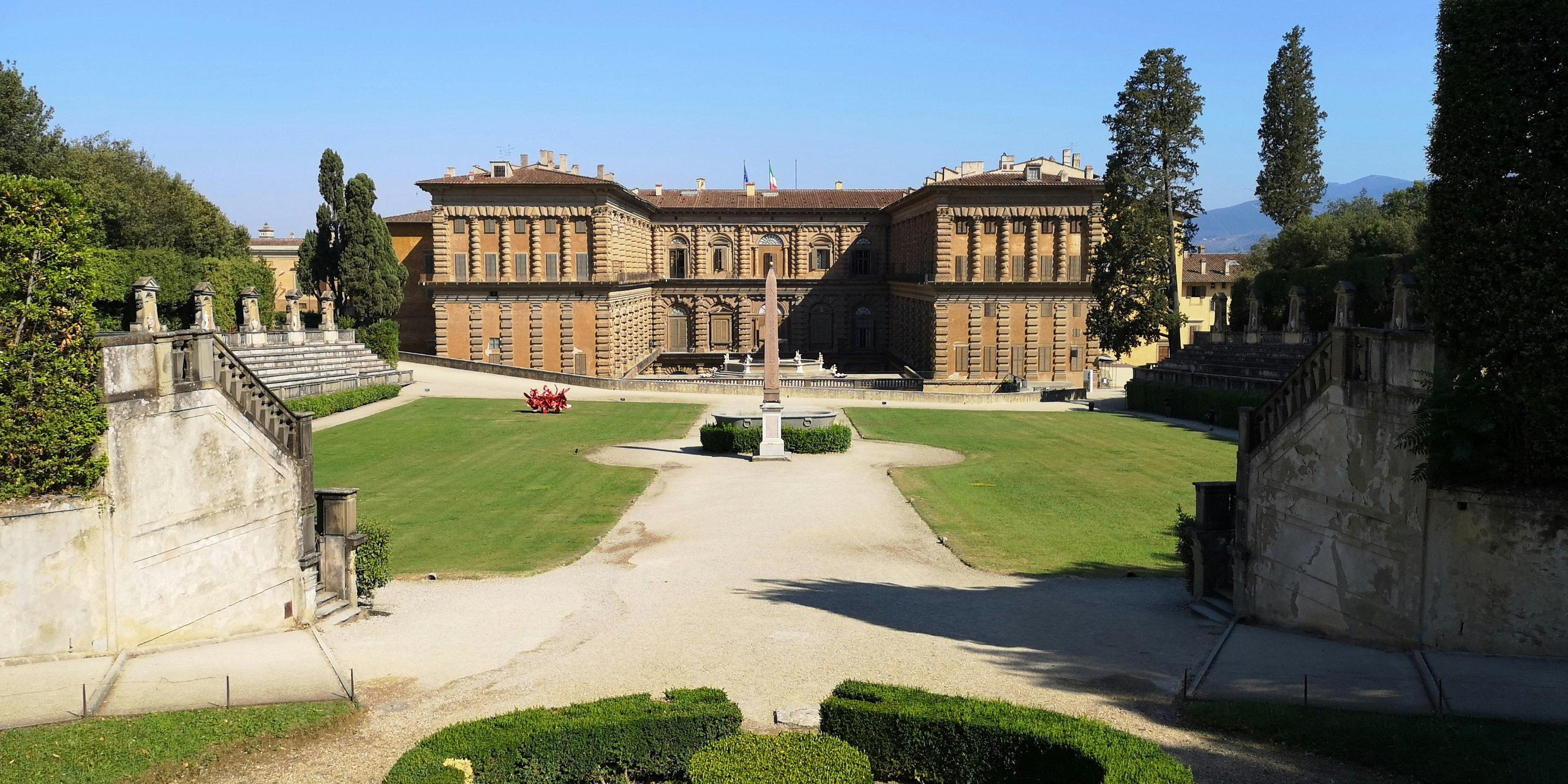 Pitti Palace seen across clipped lawns and hedges from the Boboli Gardens