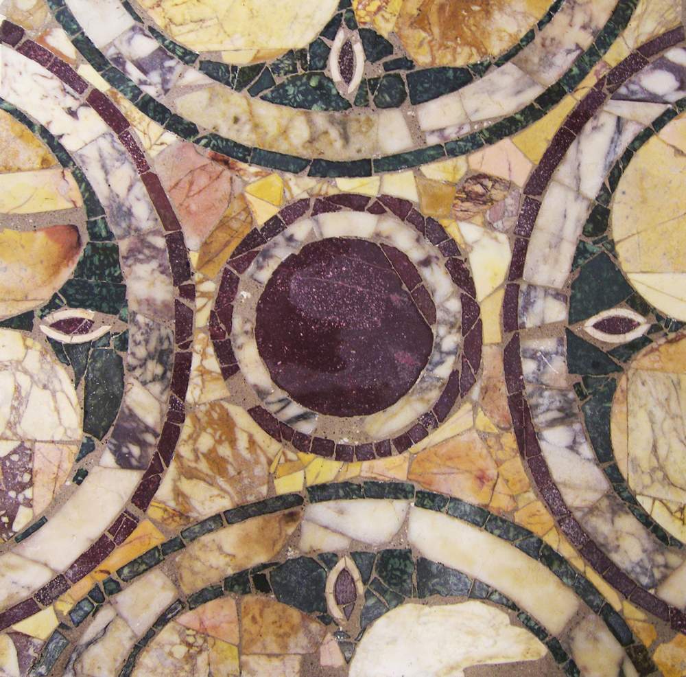 Close-up of an ancient inlaid marble floor with circles of porphyry and coloured stone