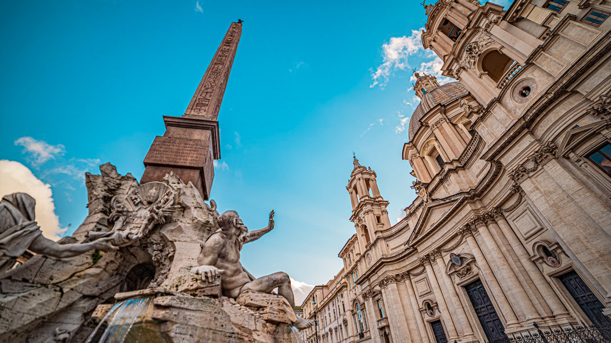 Low view of the Four Rivers Fountain, the obelisk and the Baroque church facade in Piazza Navona