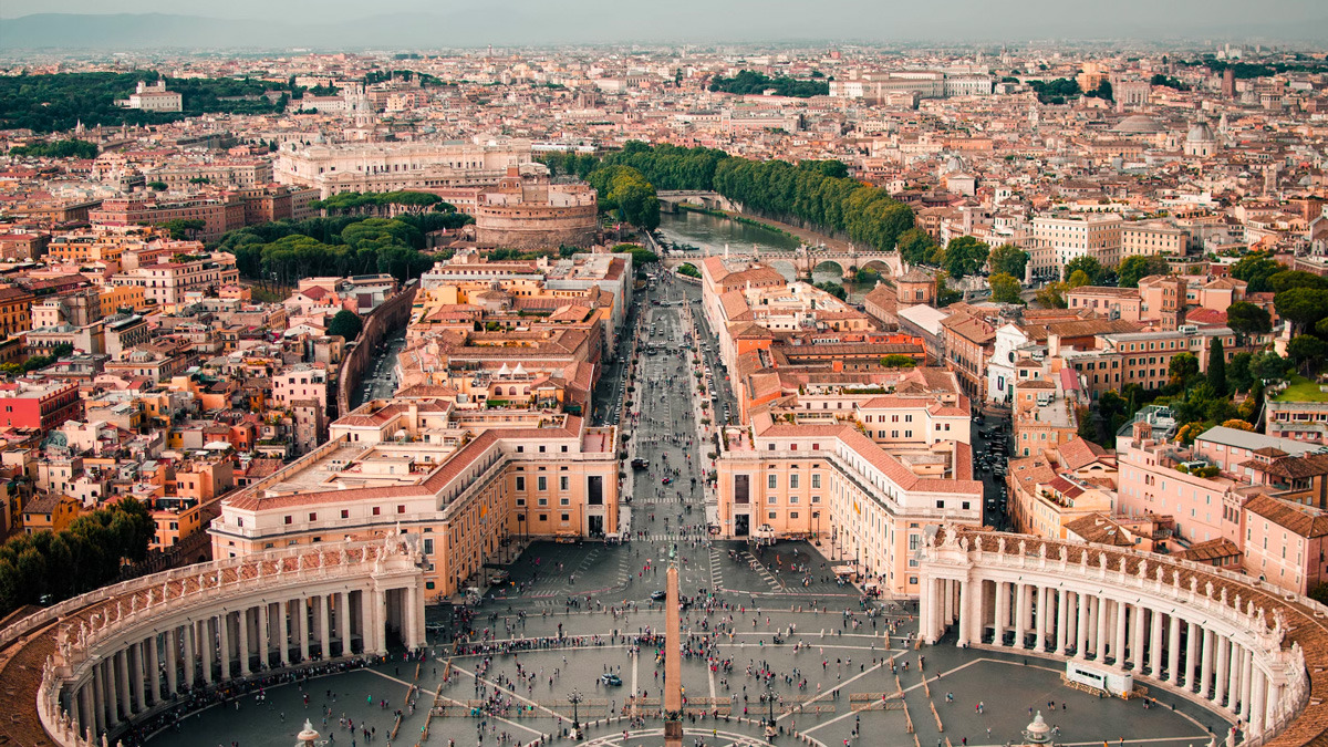 Aerial view of the colonnades of Saint Peter's Square and the rooftops of Rome